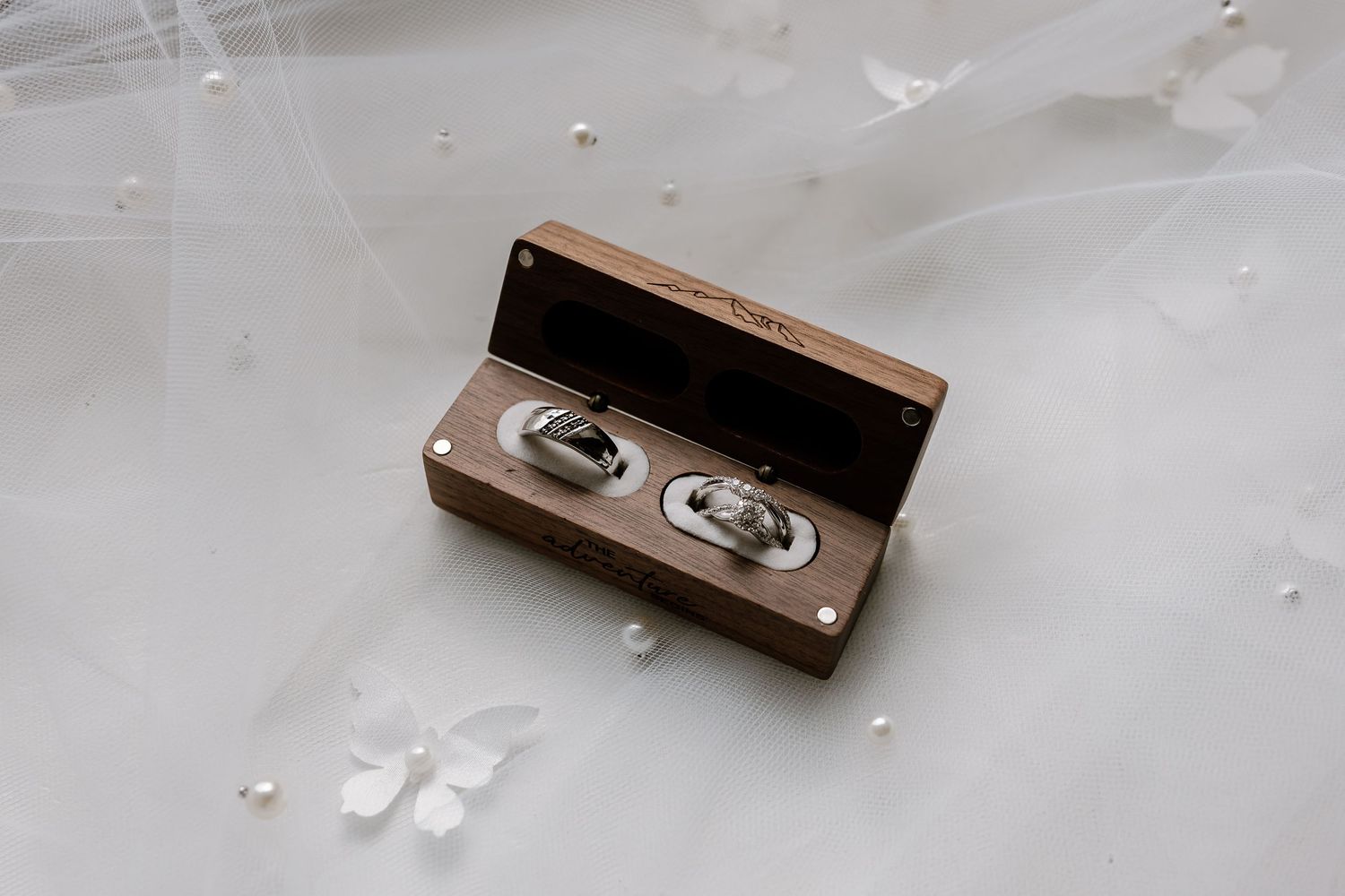Small wooden box and delicate white decorative elements on a light surface.