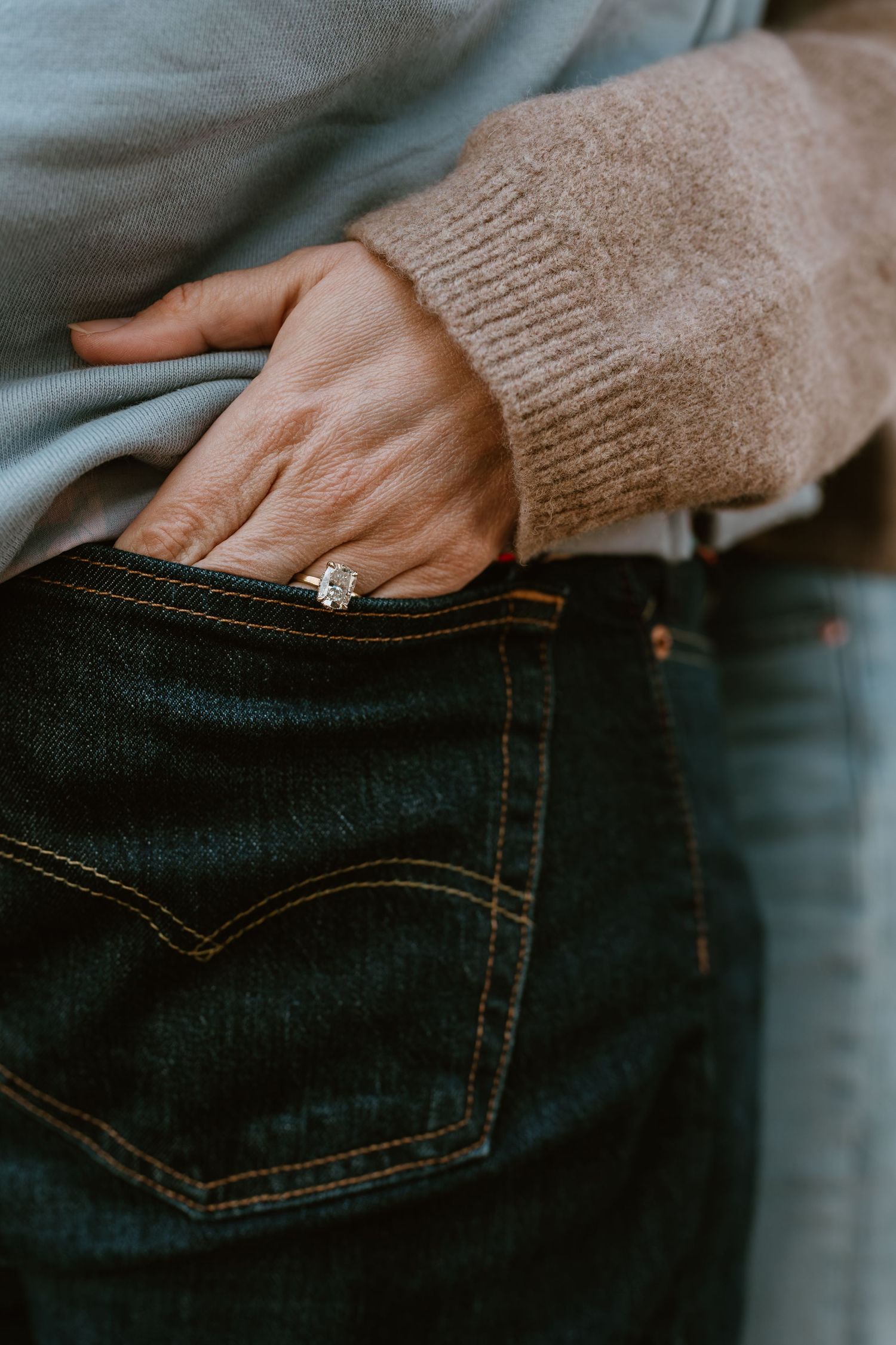 Close-up shots of hands resting against dark denim jeans pockets.