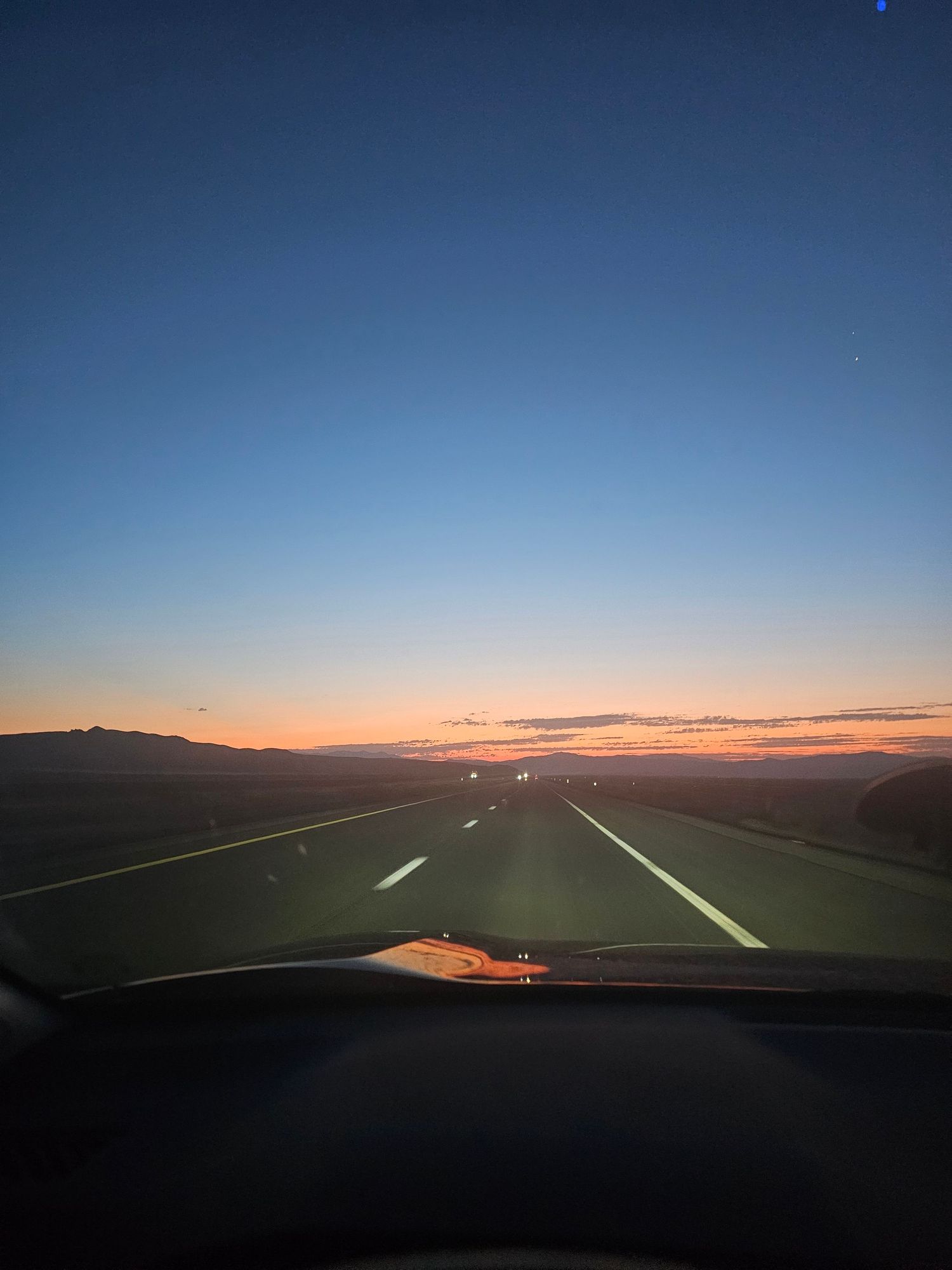A series of scenic sunset photos captured through a car windshield showing a dark highway stretching into the horizon.