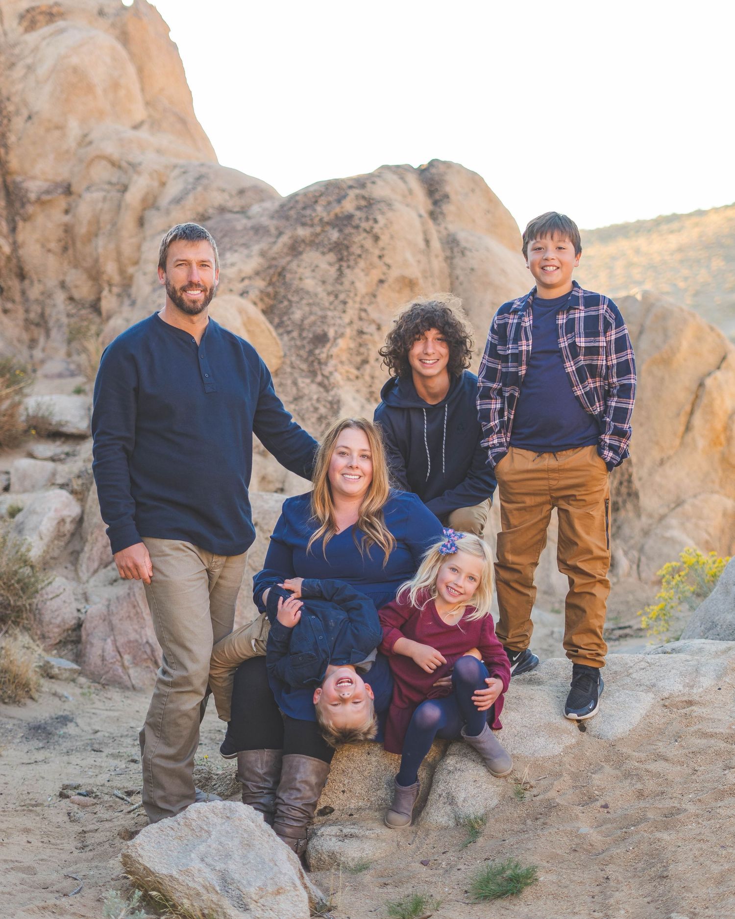 Family of five posing outdoors at Moonrocks in Reno, Nevada, smiling together in casual fall outfits at golden hour.