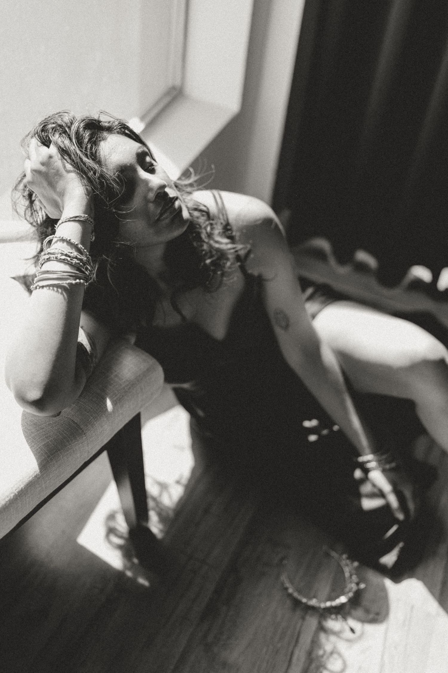 A series of black and white artistic photographs showing a person's hands and body in abstract poses against a dark background.