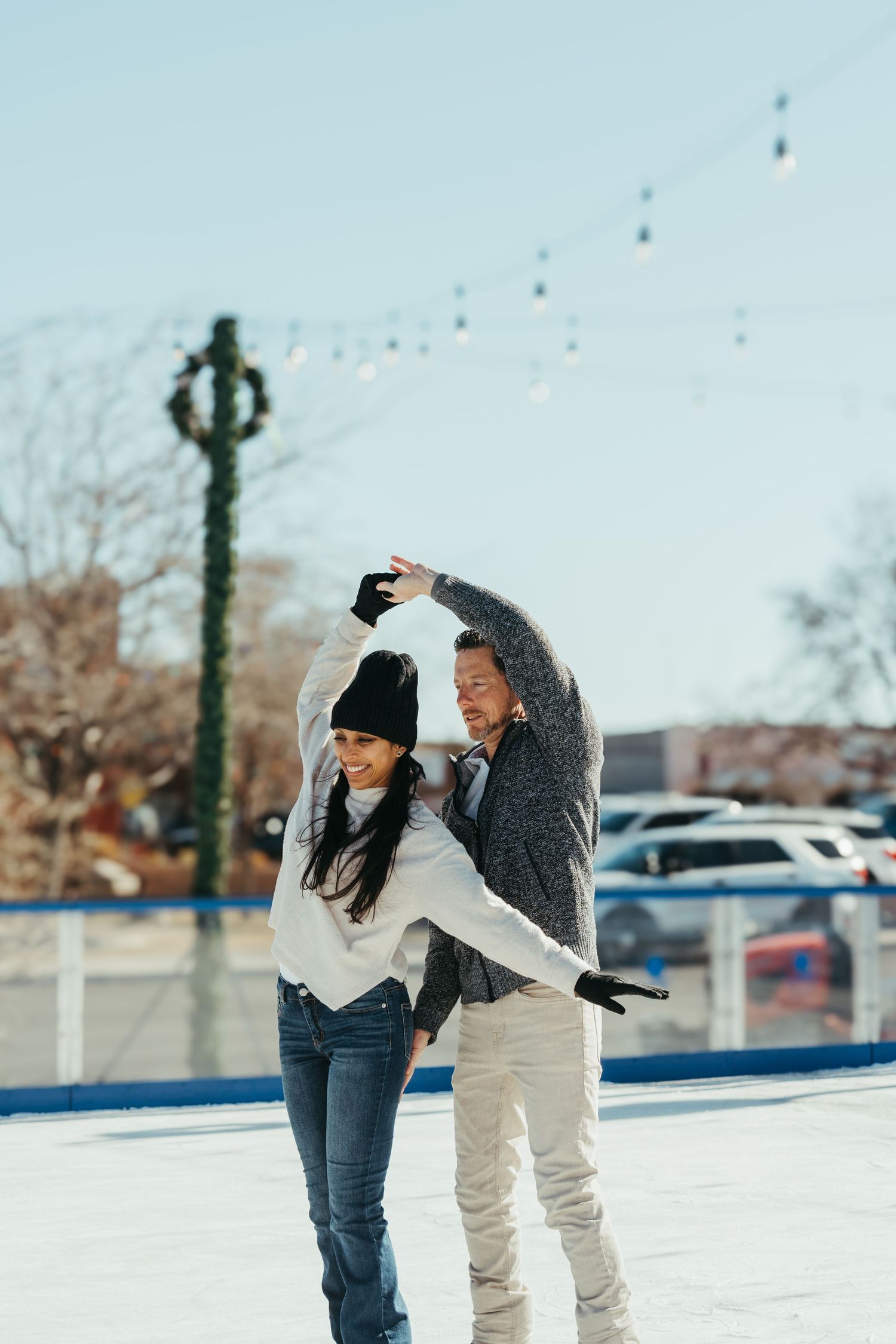 A couple playfully throws snowballs at each other in a snowy parking lot during winter.