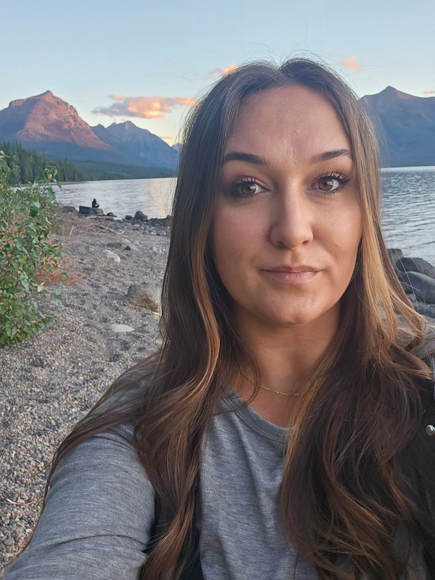 A series of selfie photos taken at sunset by a lake with mountains in the background.