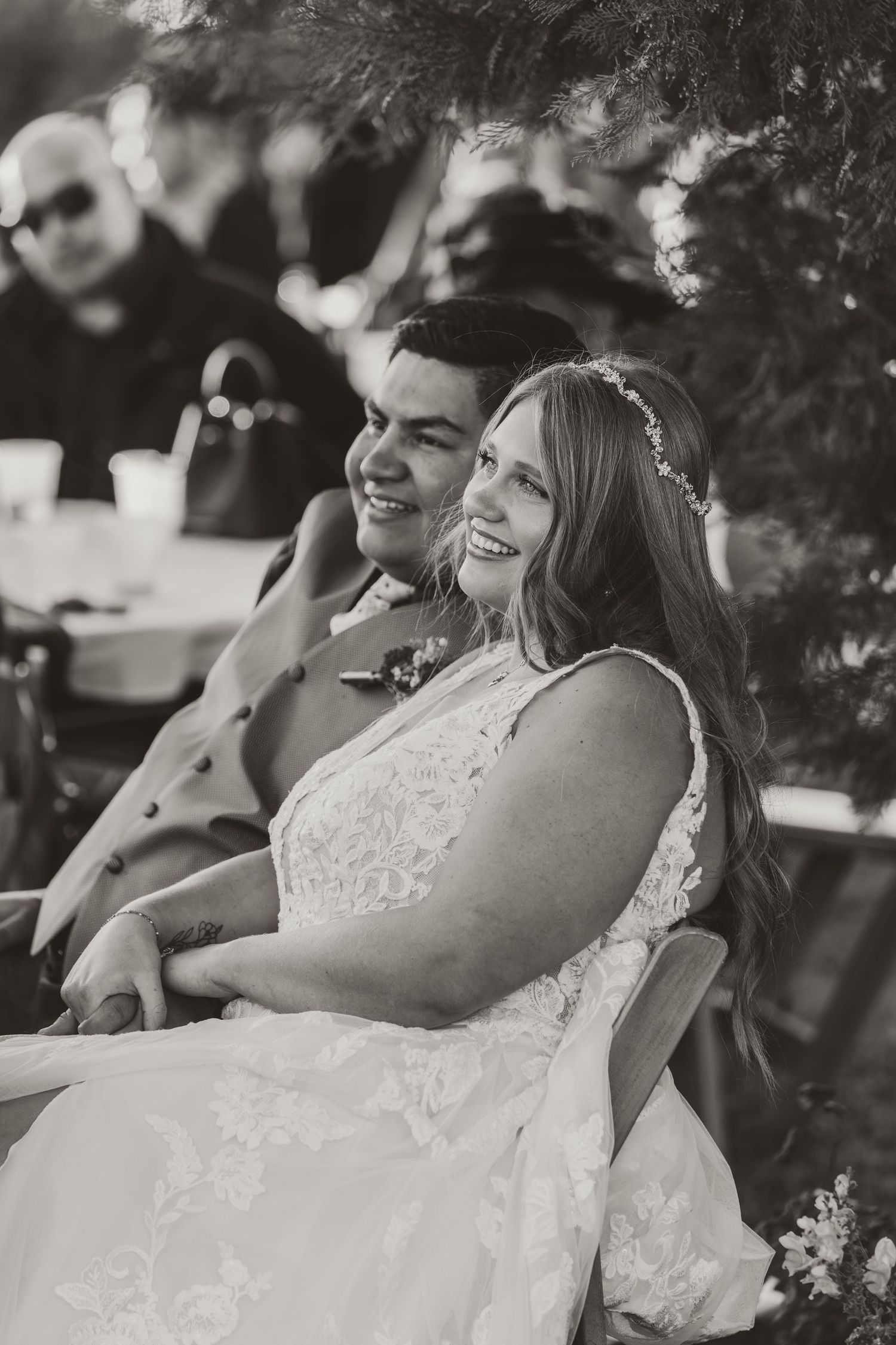 A joyful black and white wedding photo showing a couple laughing together during their outdoor reception in Fernley, Nevada.