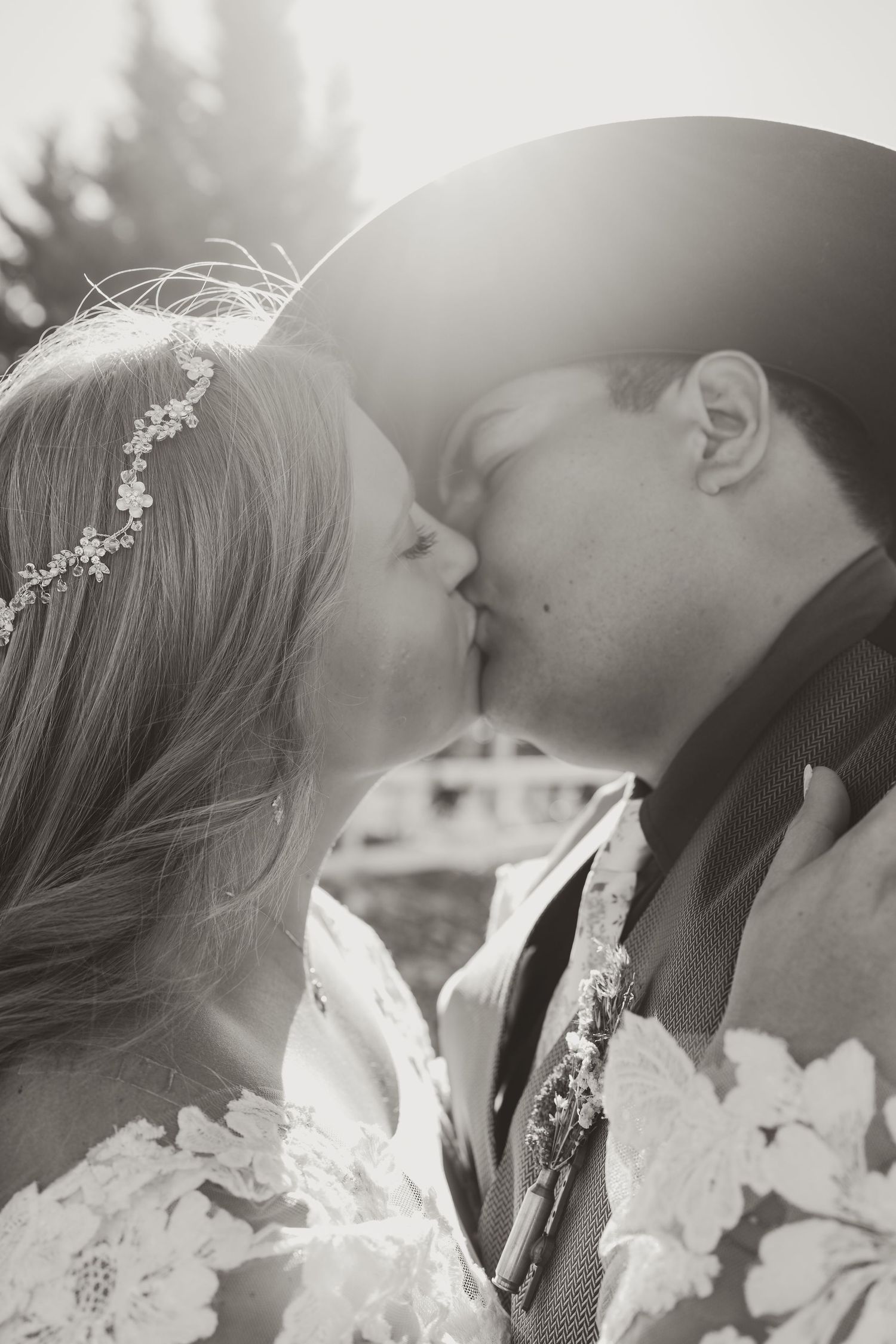 A romantic black and white photo series showing a couple sharing intimate moments in wedding attire with soft lighting.