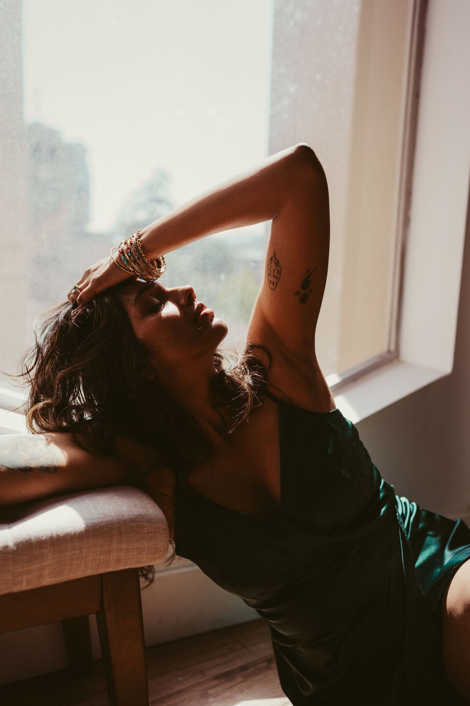 A series of silhouetted photos showing a person reclining against a window in dramatic lighting.