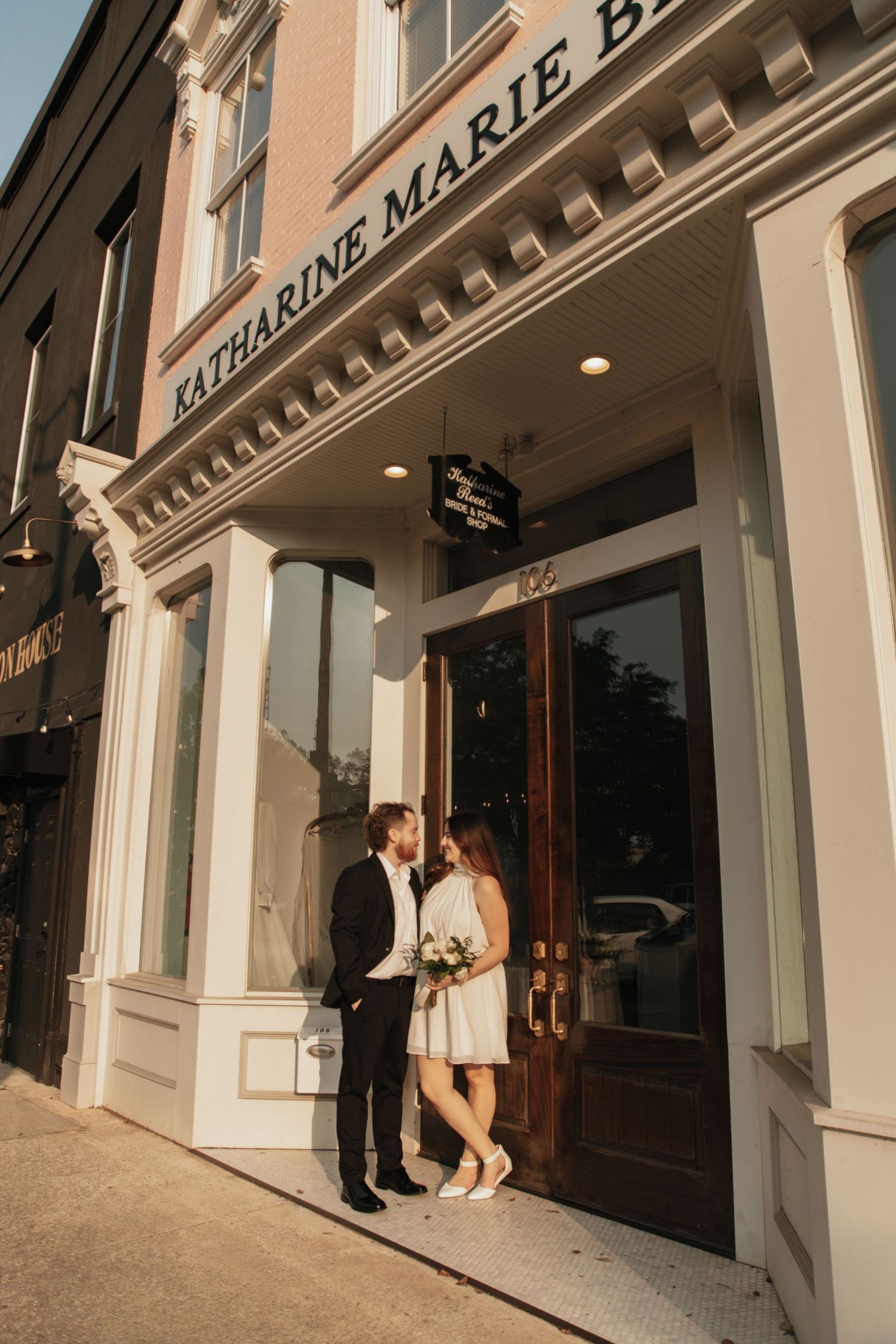 Bride and groom standing outside Katharine Marie bridal boutique on sunny wedding day. downtown anderson sc