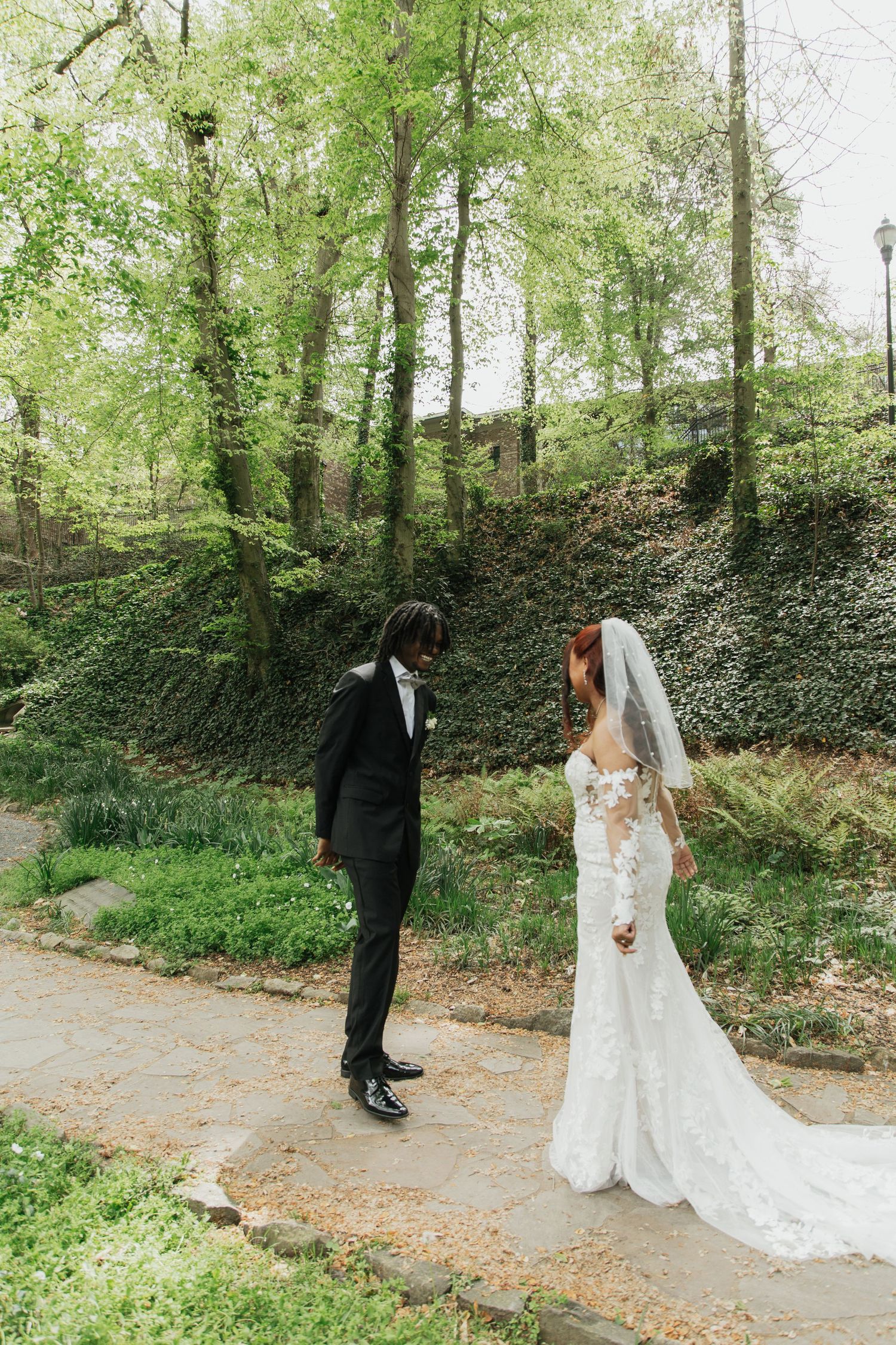 Bride and groom share a romantic first look moment on a garden stone path.  falls park greenville sc