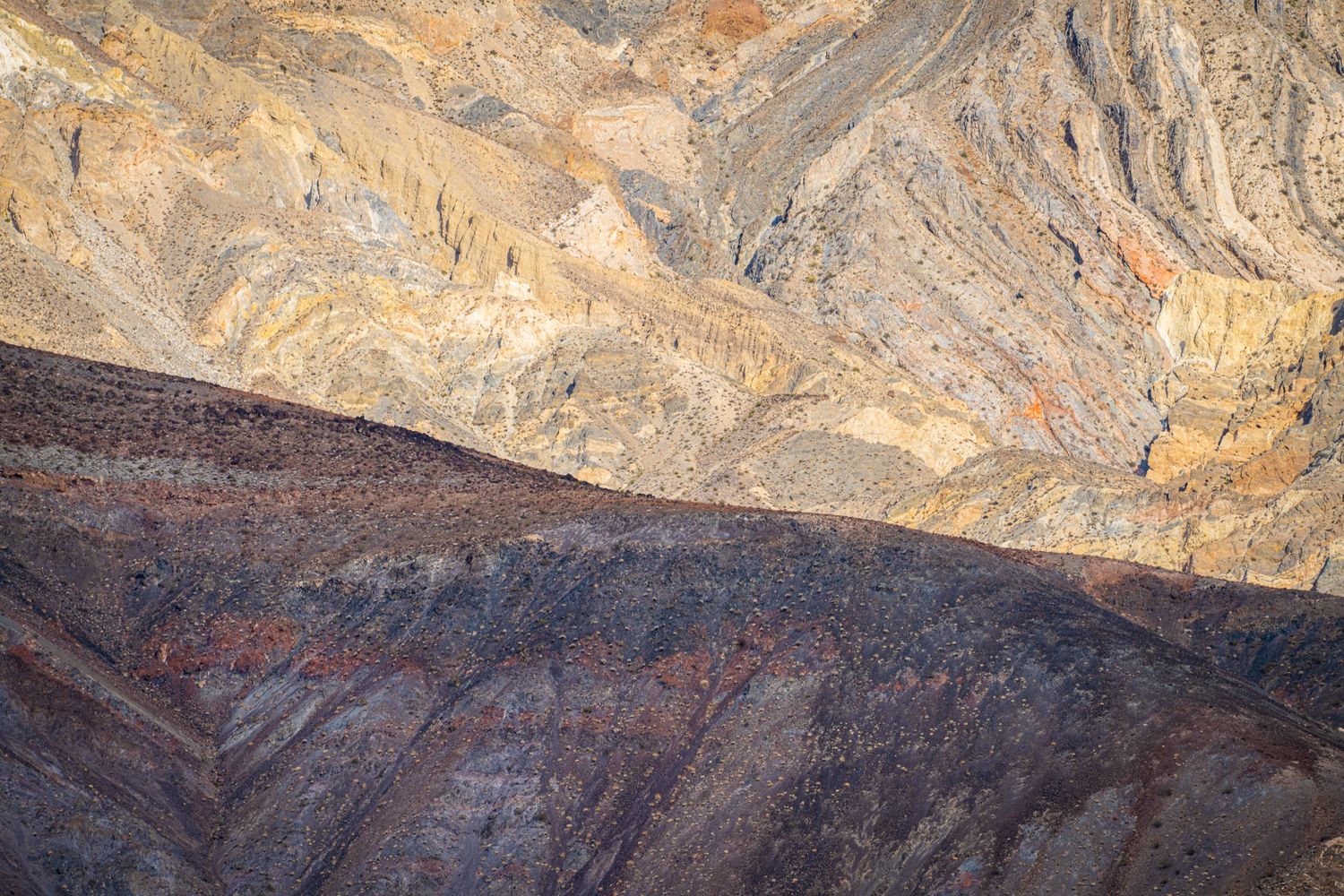 Colorful layered rock formations showing geological strata in shades of orange, red, and brown.