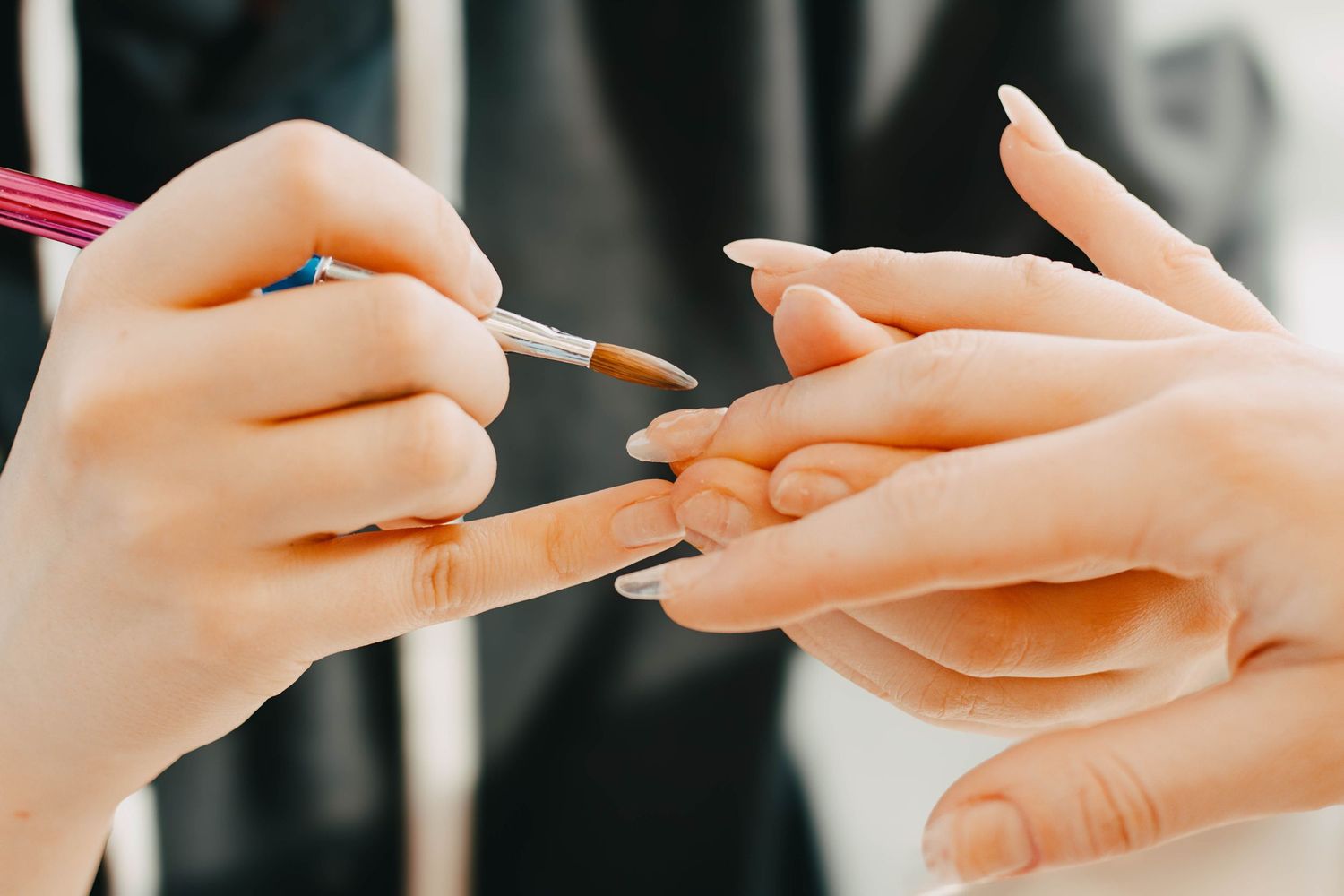 Close-up of multiple hands holding chopsticks during a shared dining experience at an Asian restaurant.