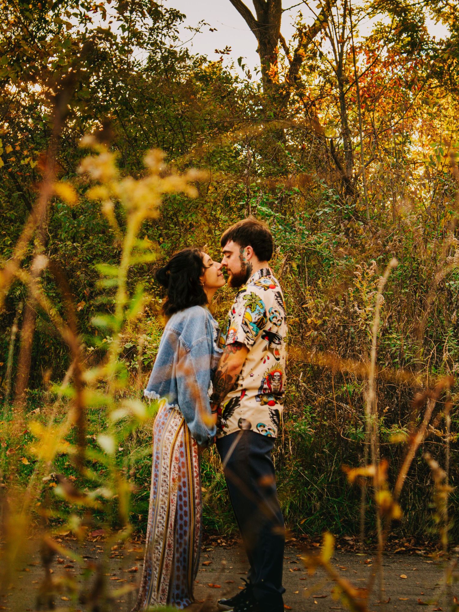 Romantic autumn photoshoot featuring couple in coordinated outfits among fall foliage.