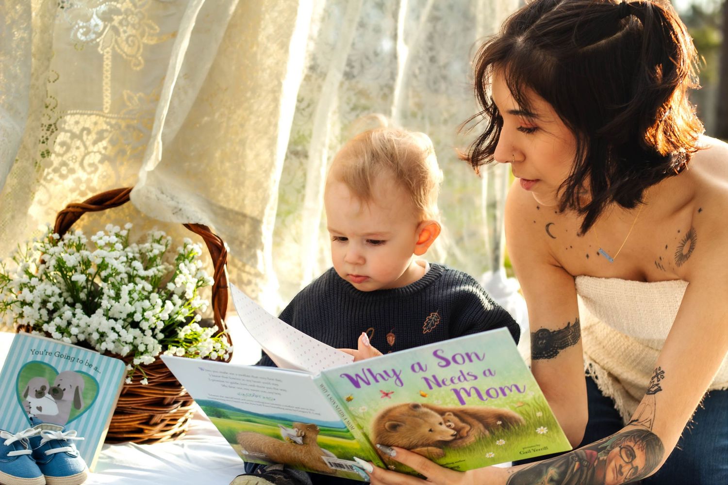 Reading a children's picture book together on a sunny afternoon with a basket of white flowers nearby.