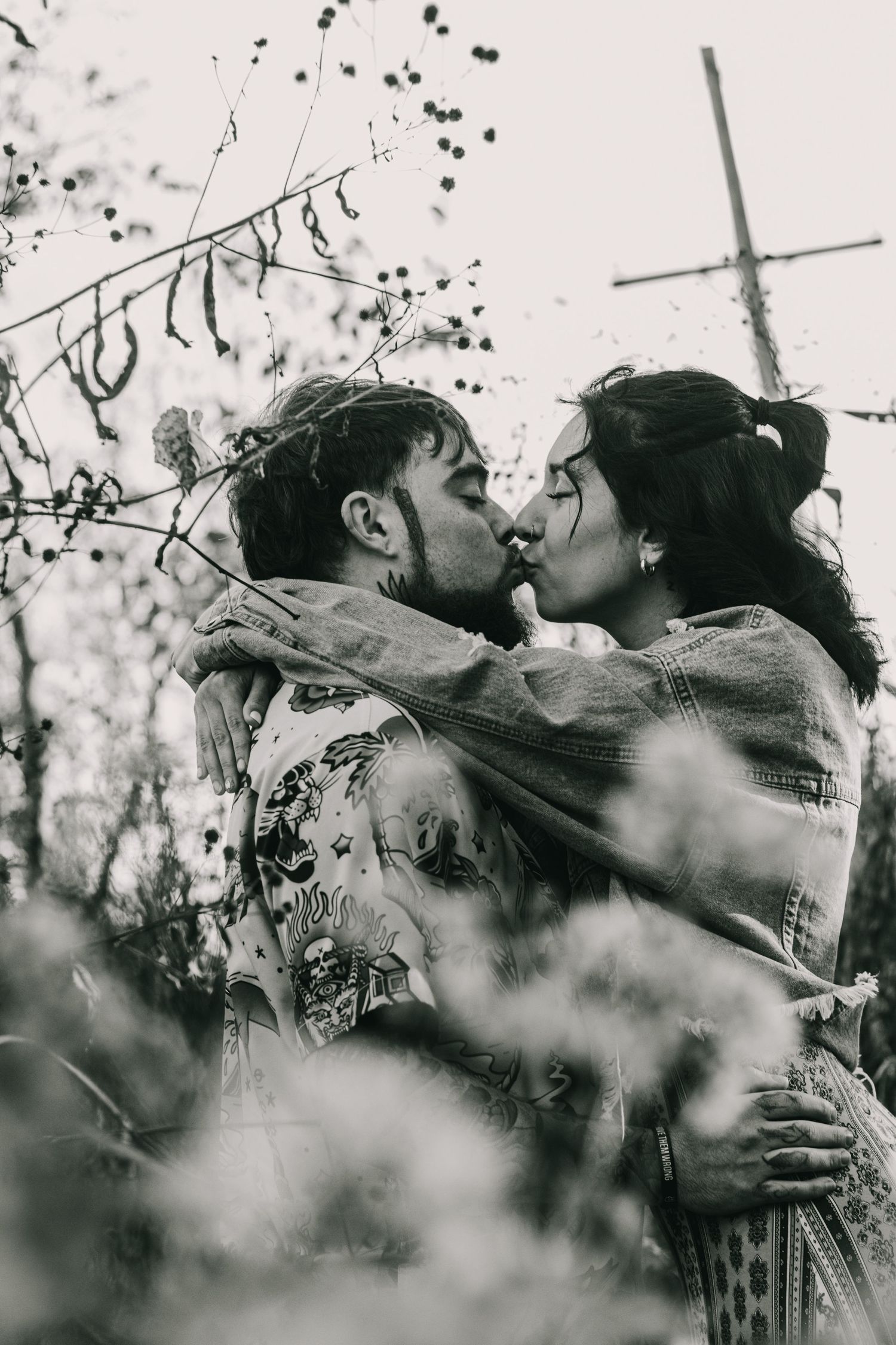 A romantic black and white photo sequence showing a tender embrace among foliage.