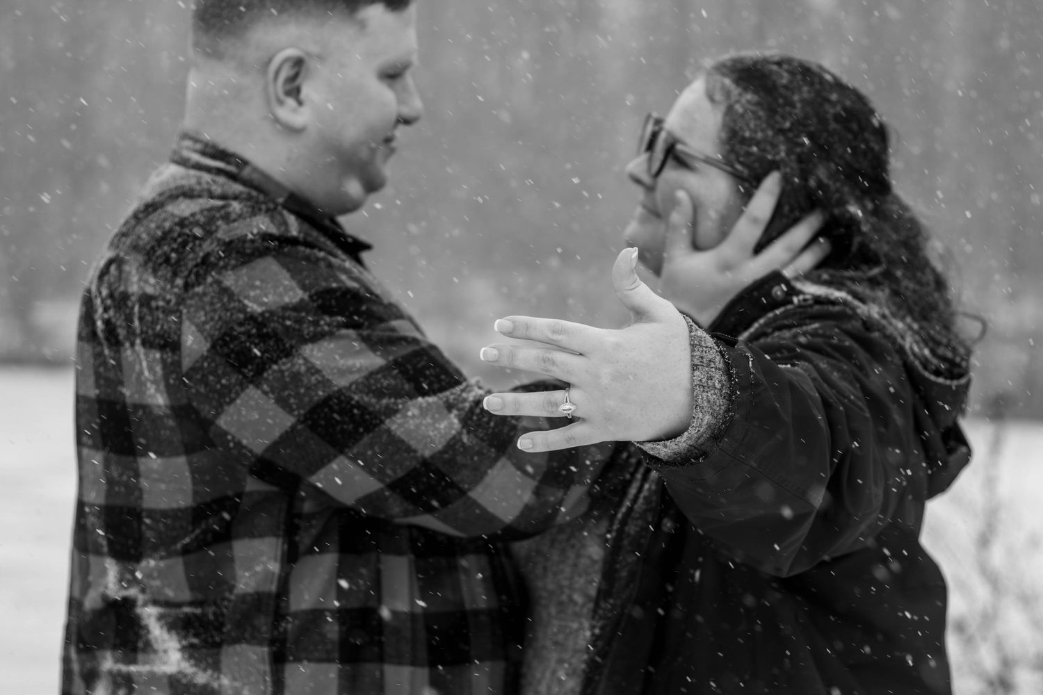 A black and white photo of a couple sharing an emotional moment in the snow.