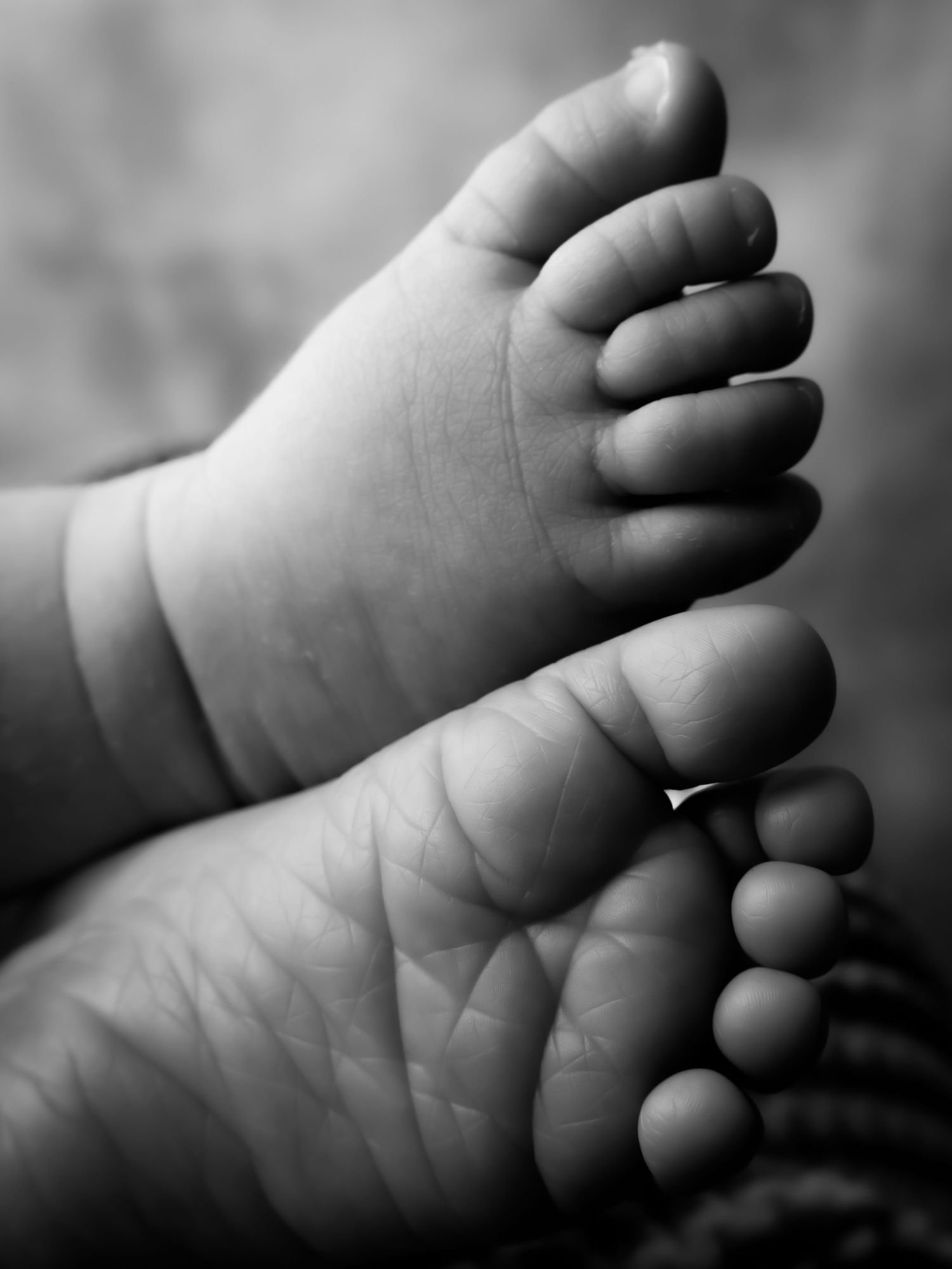 Close-up black and white sequence showing tiny baby toes and foot details.