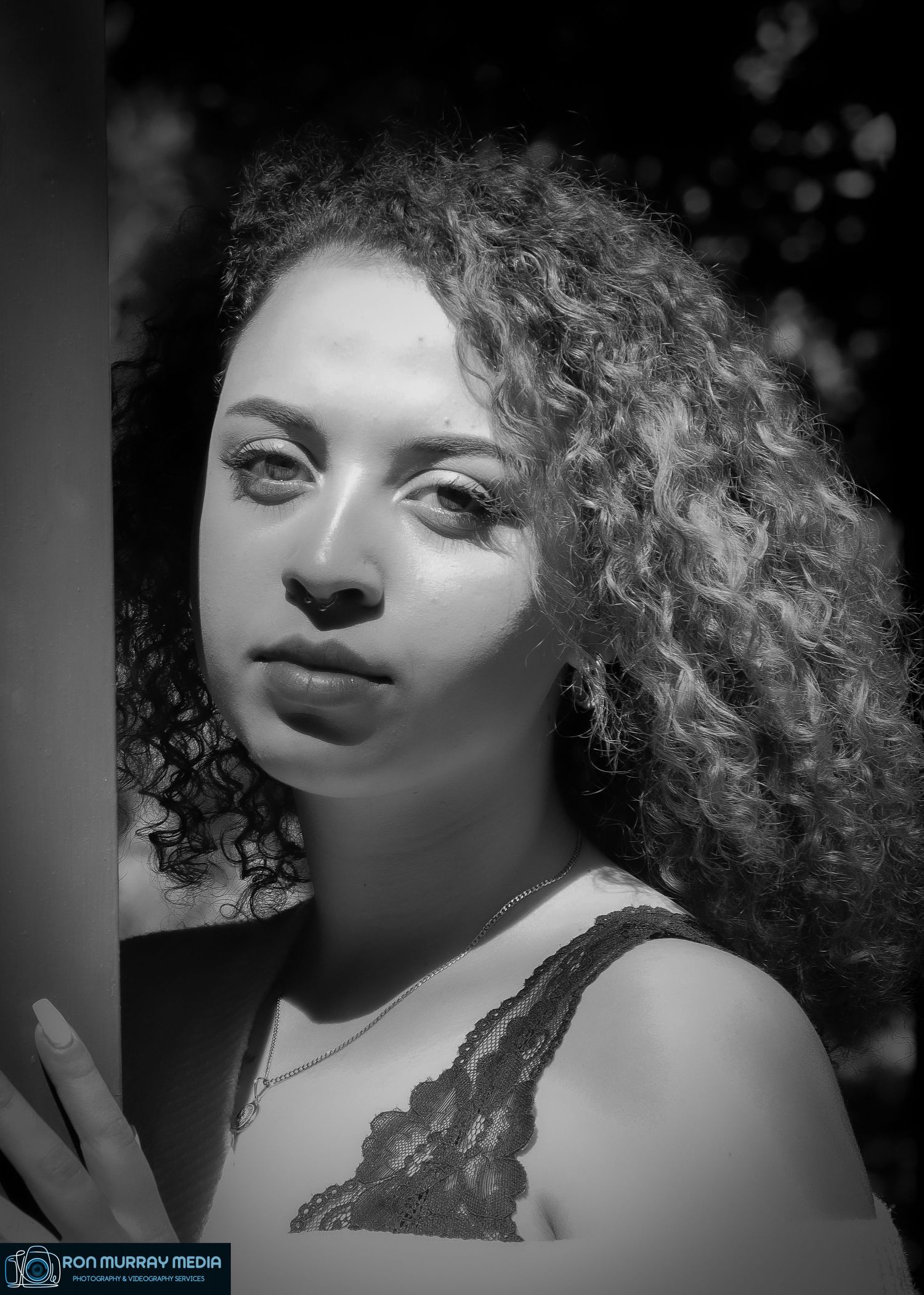 Artistic black and white portrait series showing dramatic lighting and curly hair.