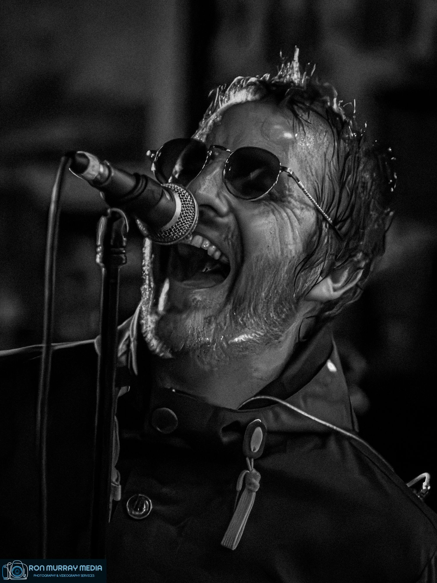 Dramatic black and white performance sequence of musician singing intensely into microphone.