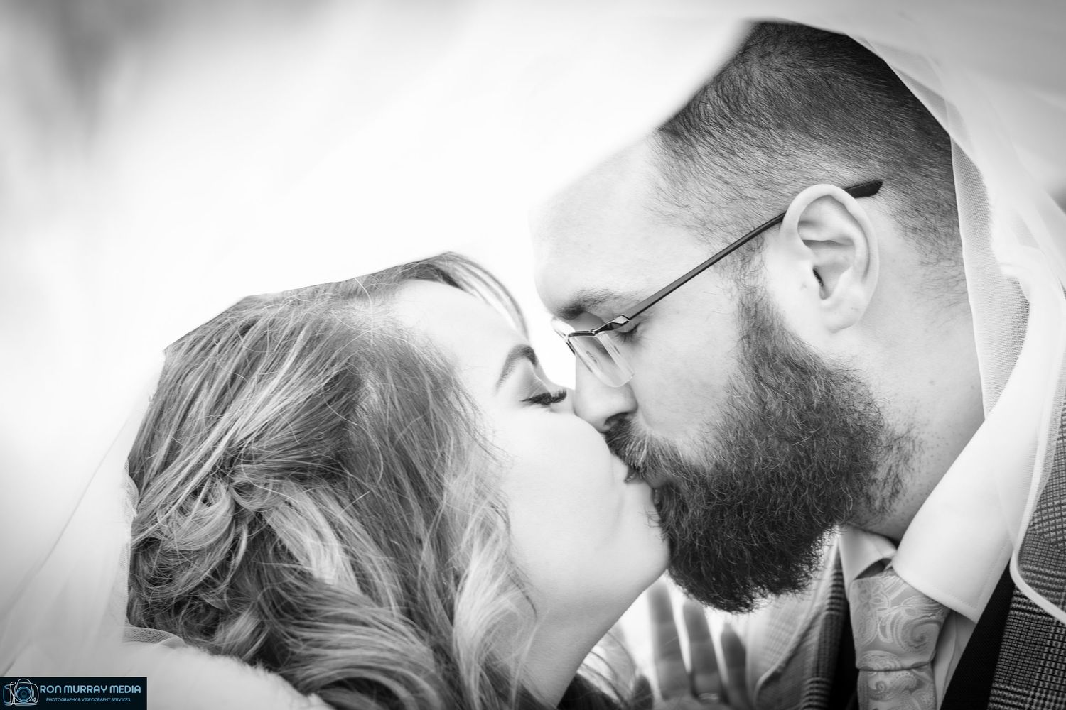 An intimate black and white close-up portrait of a couple sharing a romantic moment.