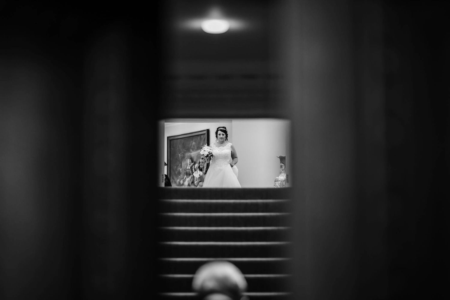 Minimalist black and white architectural wedding venue photo showing stairs and lighting.
