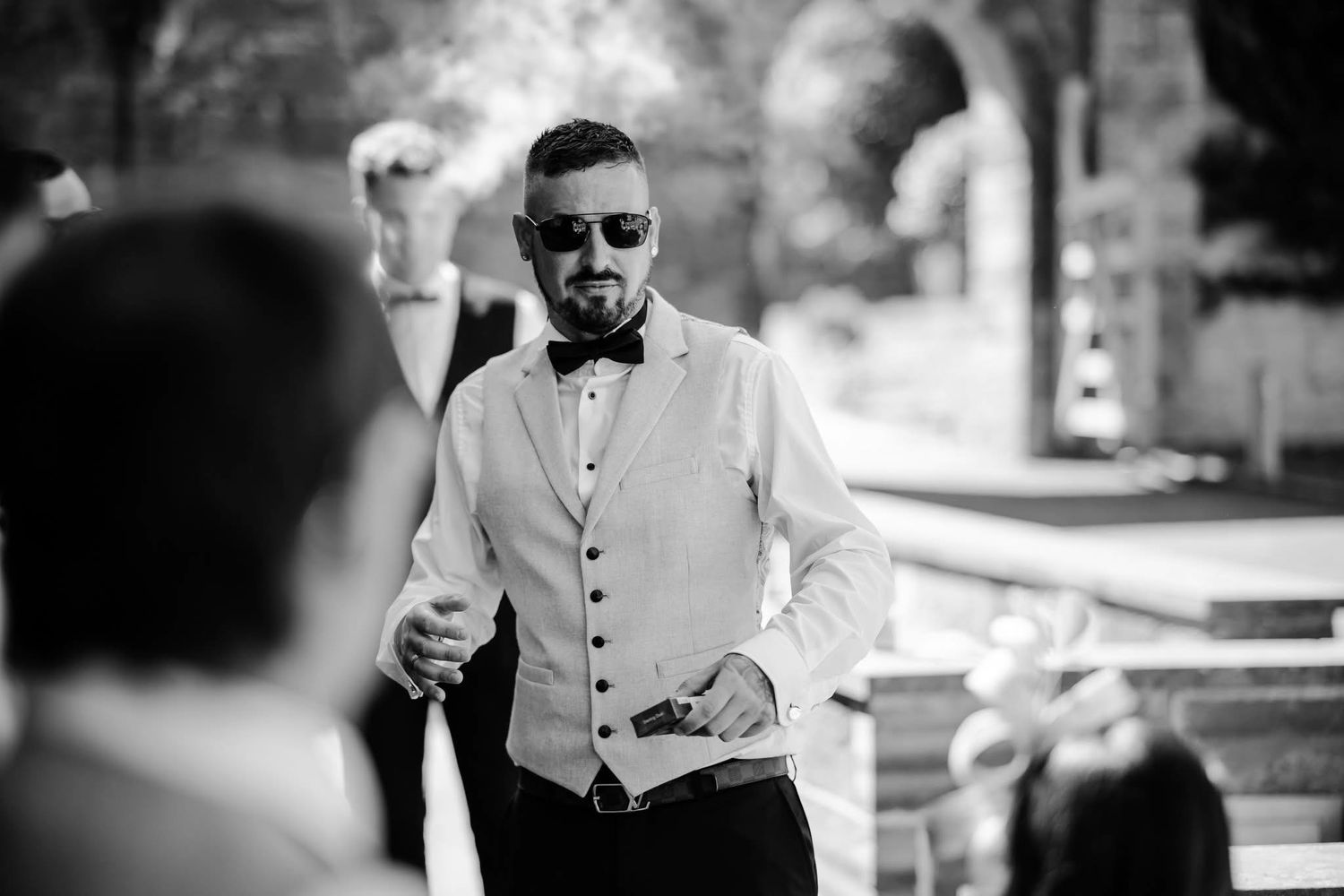Black and white candid shots of wedding guests mingling at the reception.