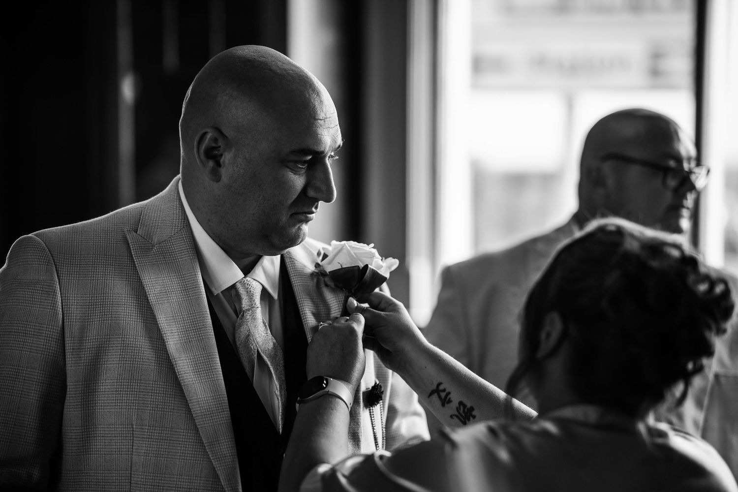 A black and white collage of intimate wedding moments showing couples embracing and sharing tender moments together.