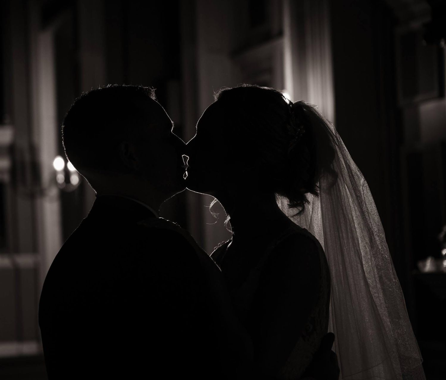 A series of romantic silhouettes show a couple embracing in low light, creating a moody and intimate atmosphere.