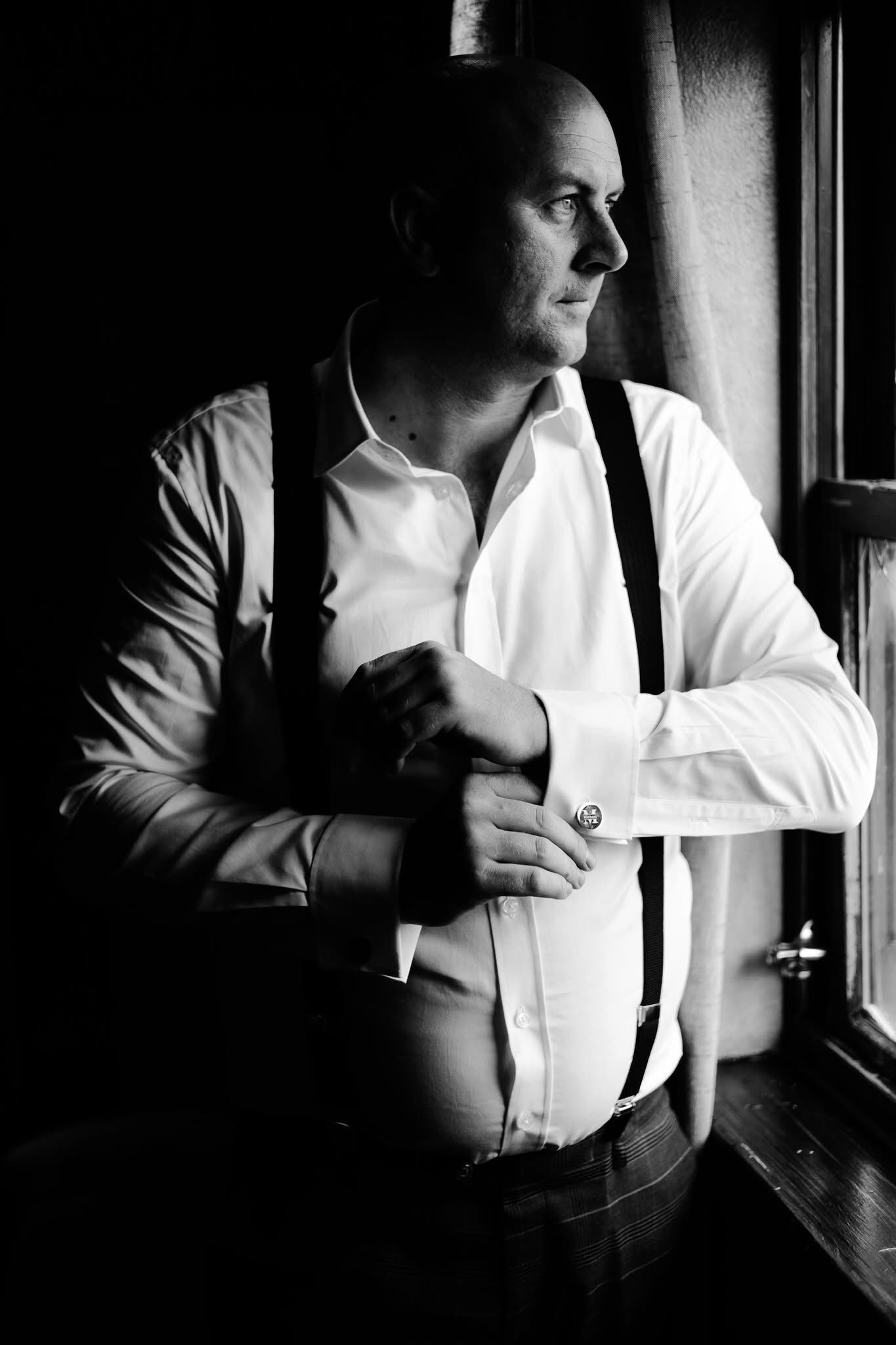 Moody black and white sequence showing a person sitting by a window in contrasting light and shadow.
