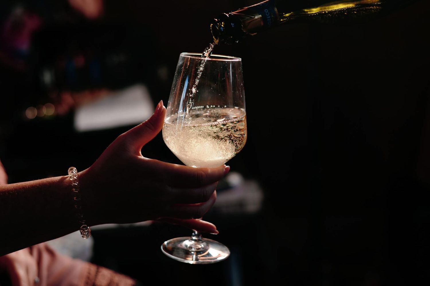Dark moody reception photo showing champagne glasses being served.