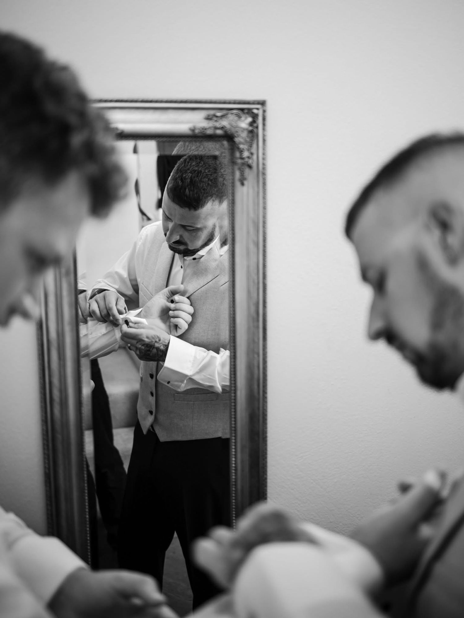 Black and white photo sequence showing someone getting ready in front of a mirror with dramatic lighting.