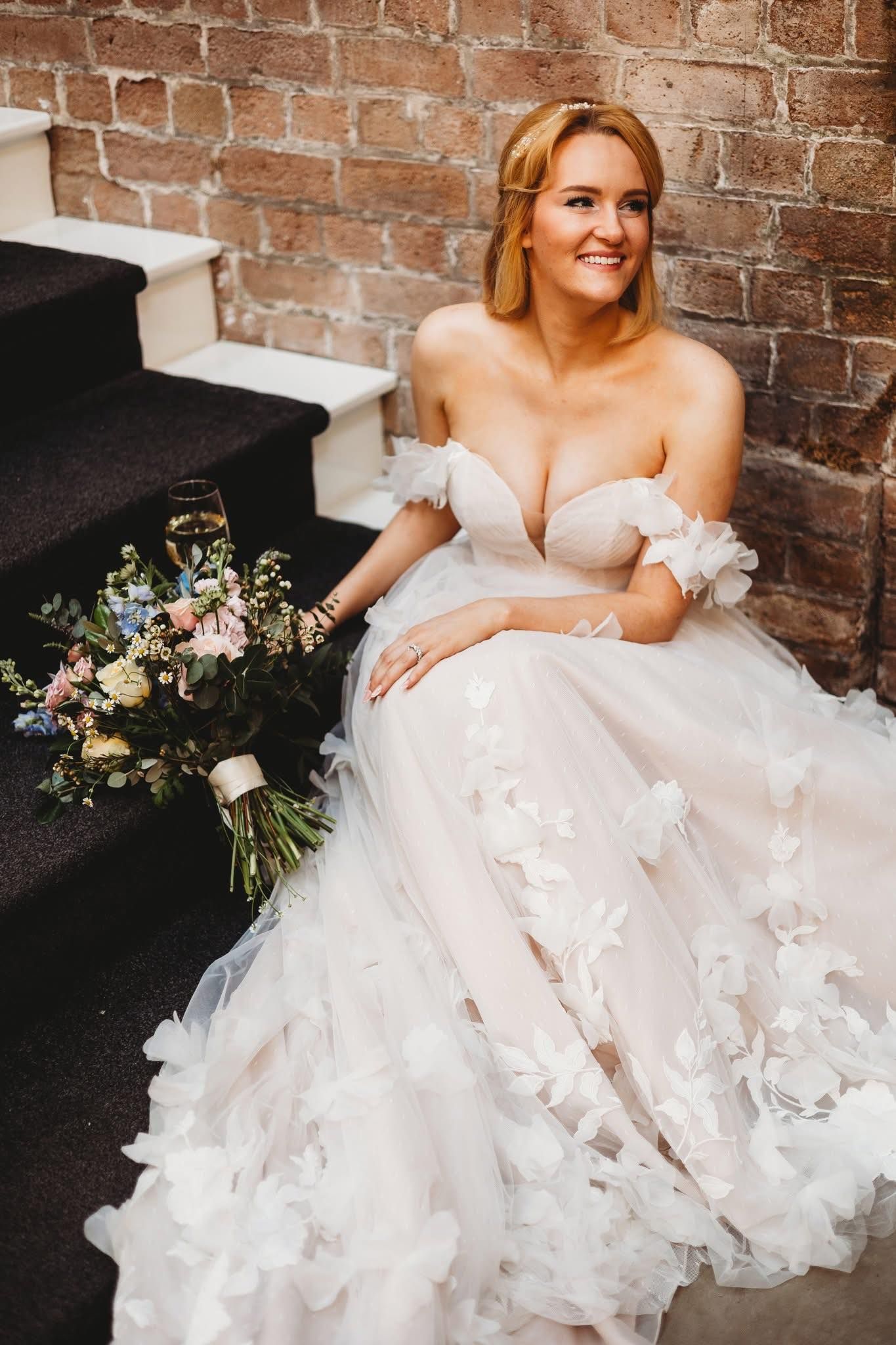 Close-up details of an ornate white wedding dress with delicate butterfly appliques.