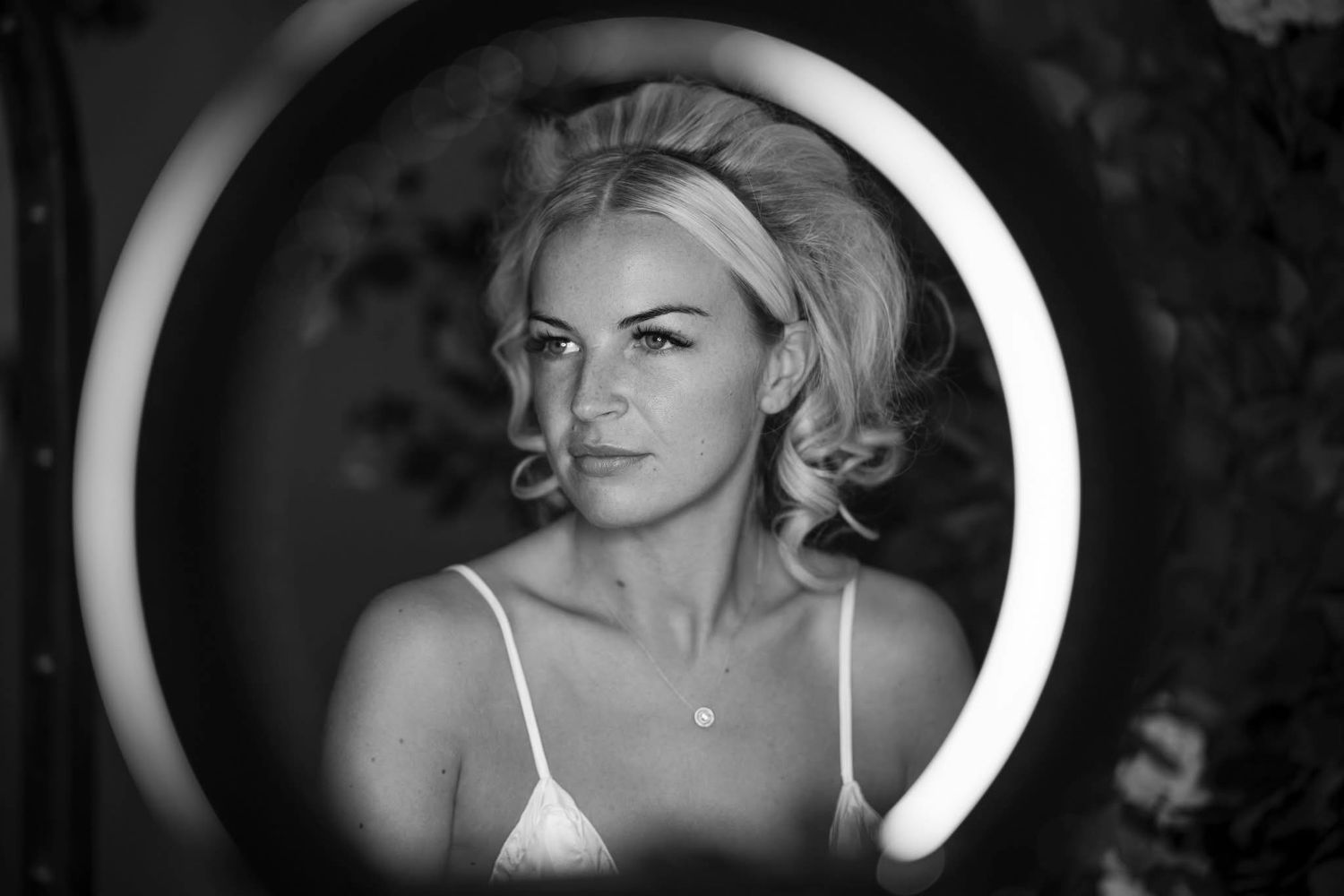 Dramatic black and white portrait through circular frame with vintage styling.