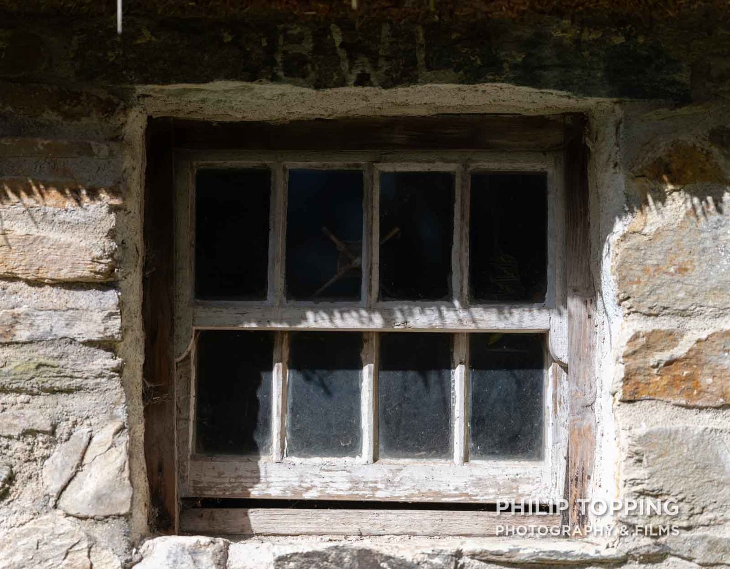 Close-up of a wooden window partly in shadow.