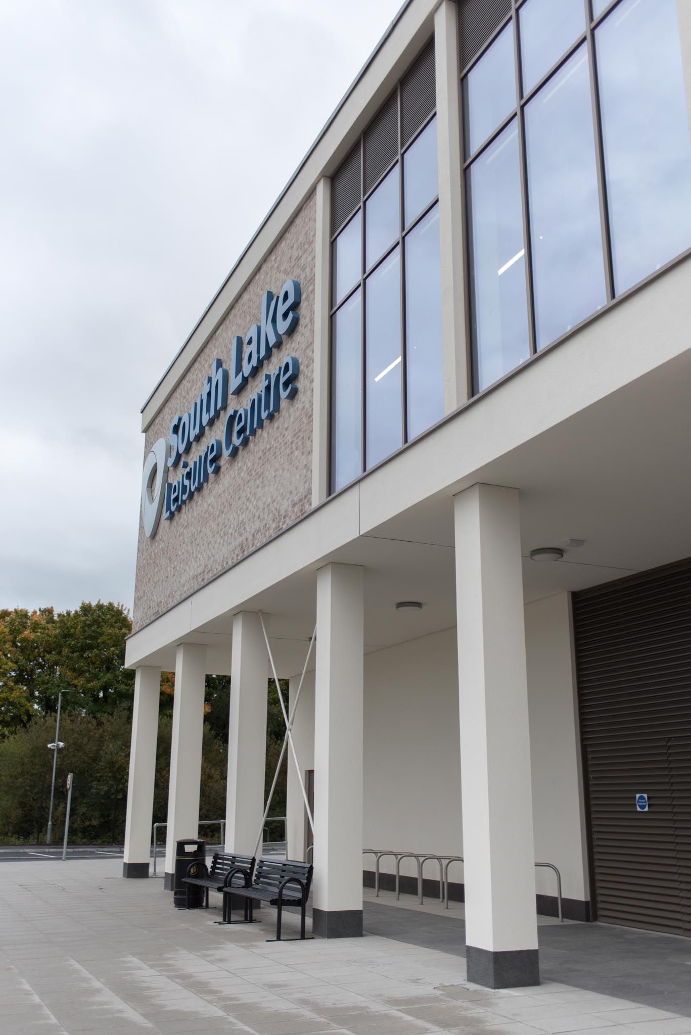 Signage on the wall in blue letters with gym to the right, photographed from outside..