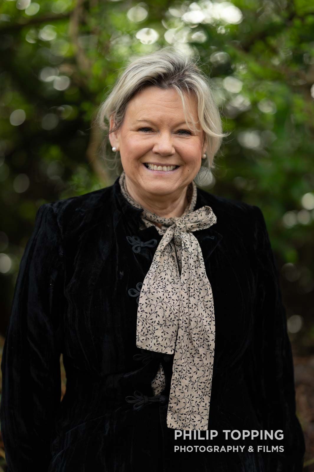 A female dressed in a historical period costume poses for a photo.