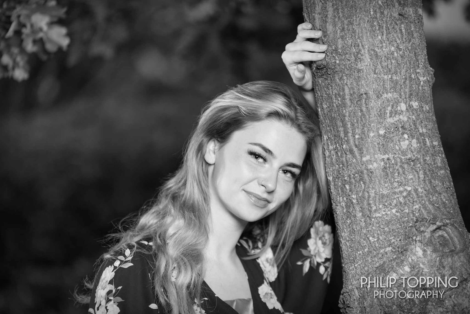 Female leaning against a tree in Tannaghmore gardens.