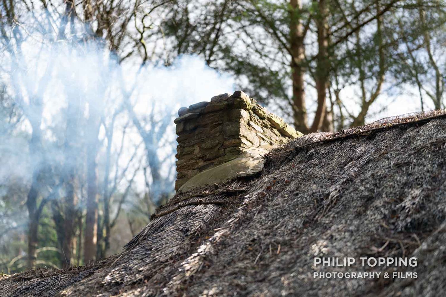 Close up of smoke coming out of the chimney at the thatched cottage.
