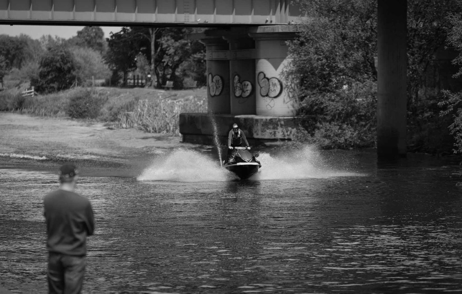 Mono image of a Jet skier under the Northway Railway Bridge.