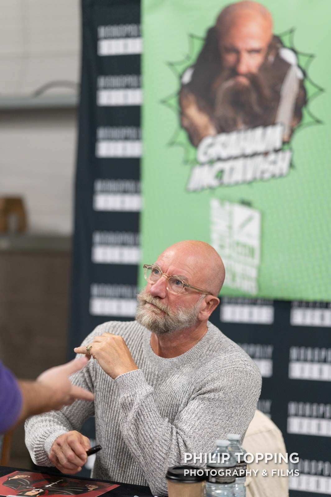 Actor Graham McTavish is sitting down talking with a fan.