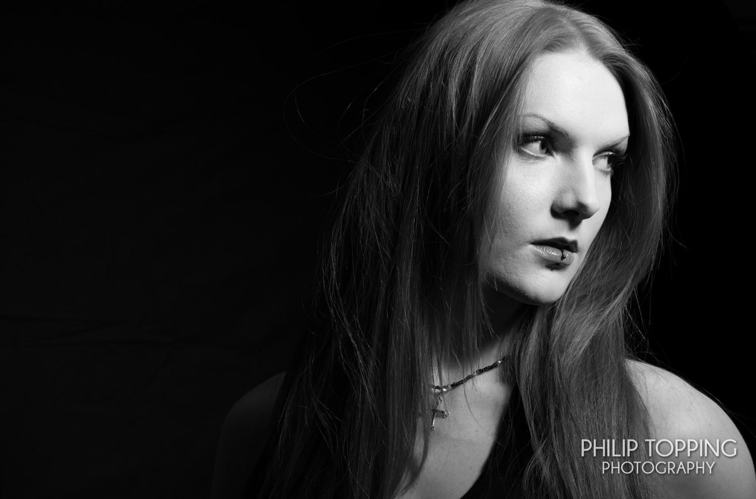 Portrait in mono black and white of a female looking to the right of the frame.