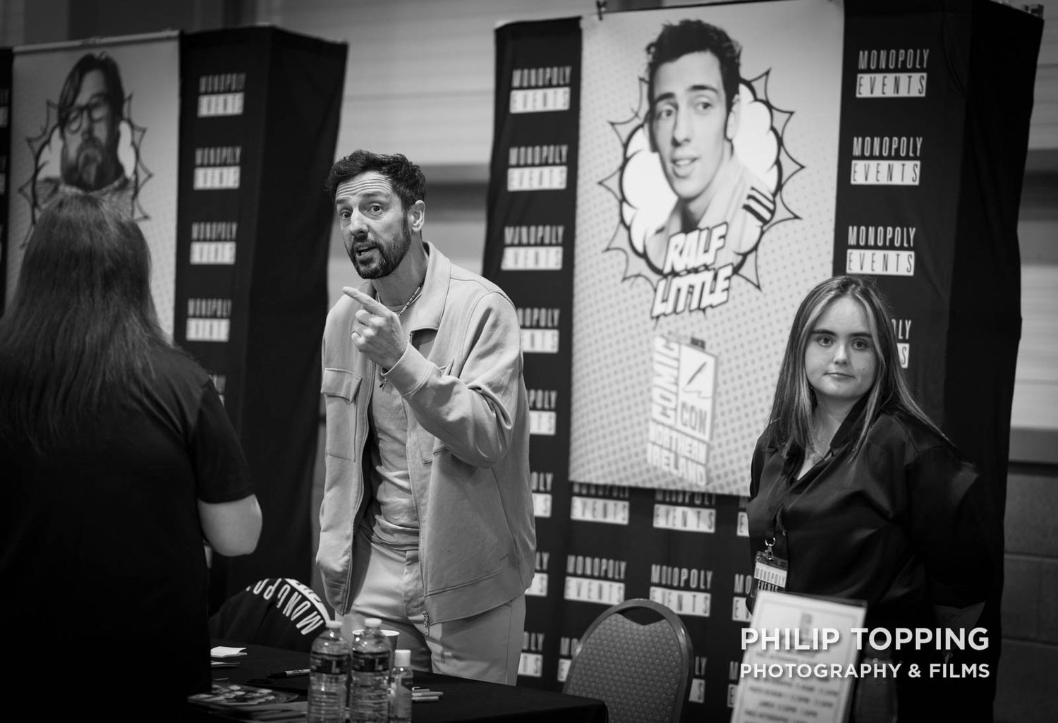 Ralf Little is standing up, chatting with someone at his table.