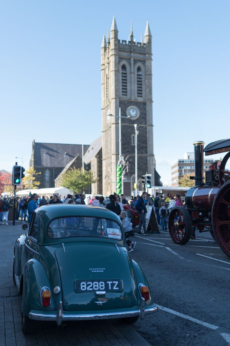 Vintage car in foreground in the shade, and St Mark’s Church of Ireland in the background with a nice blue sky.