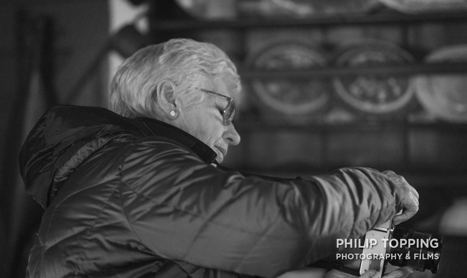 Mono image of Eileen McCausland taking a photo.