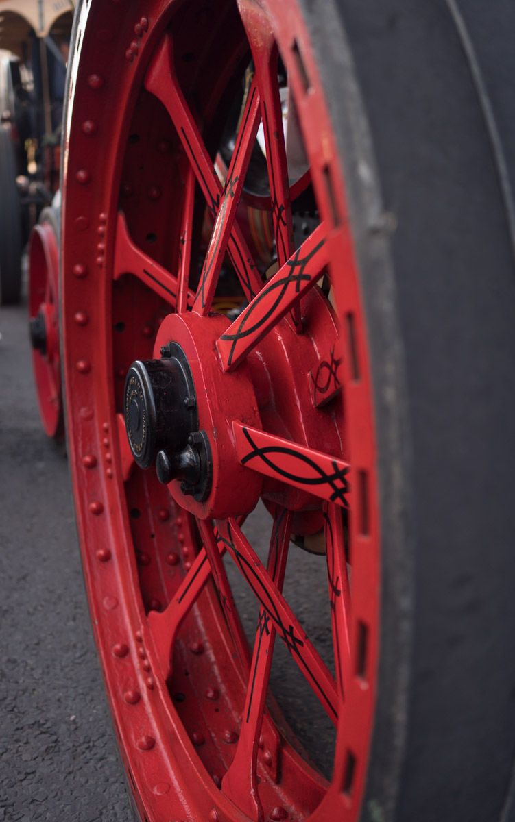 Close-up of a red wheel from a steam engine.