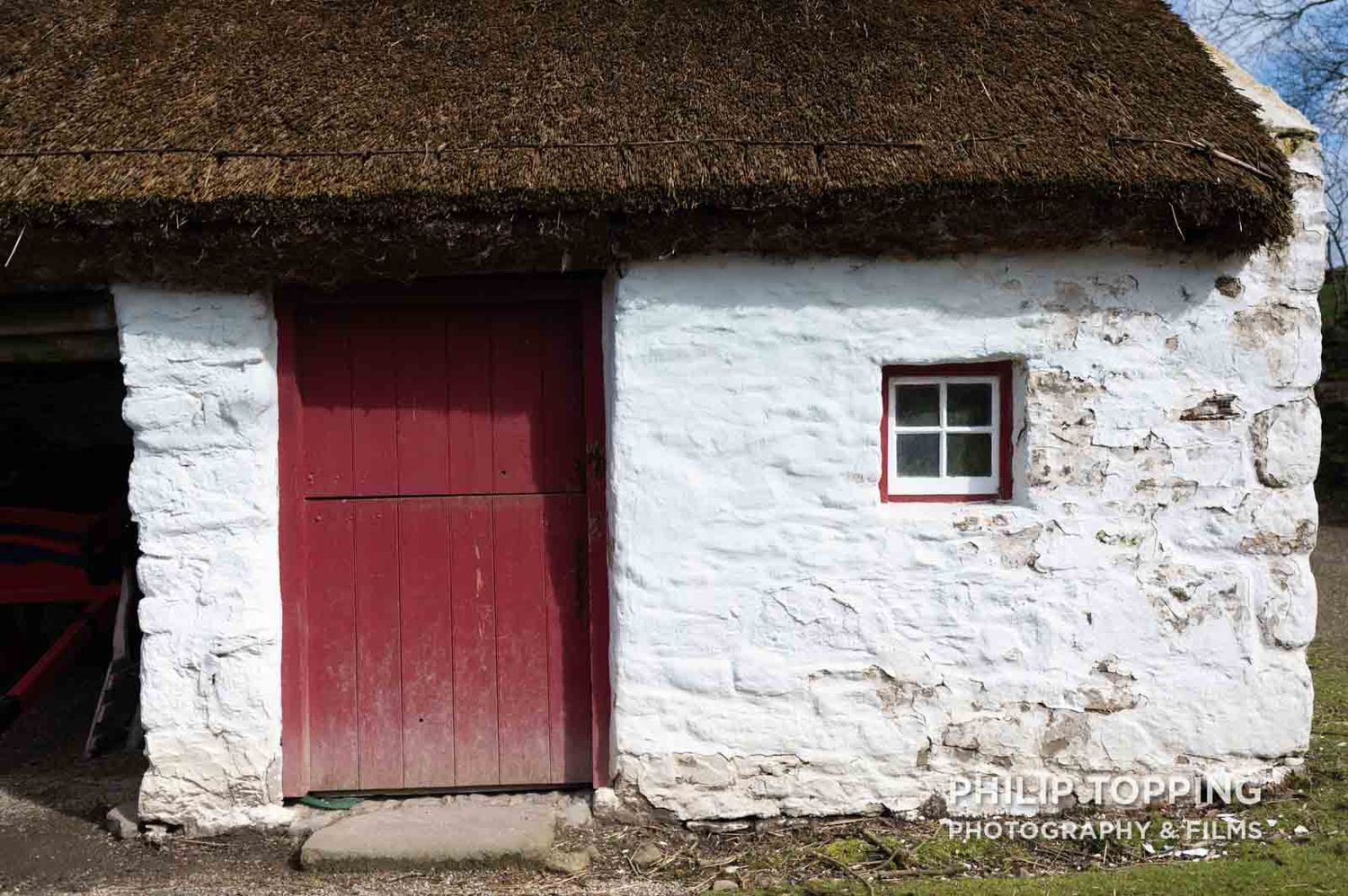 White cottage with red door.