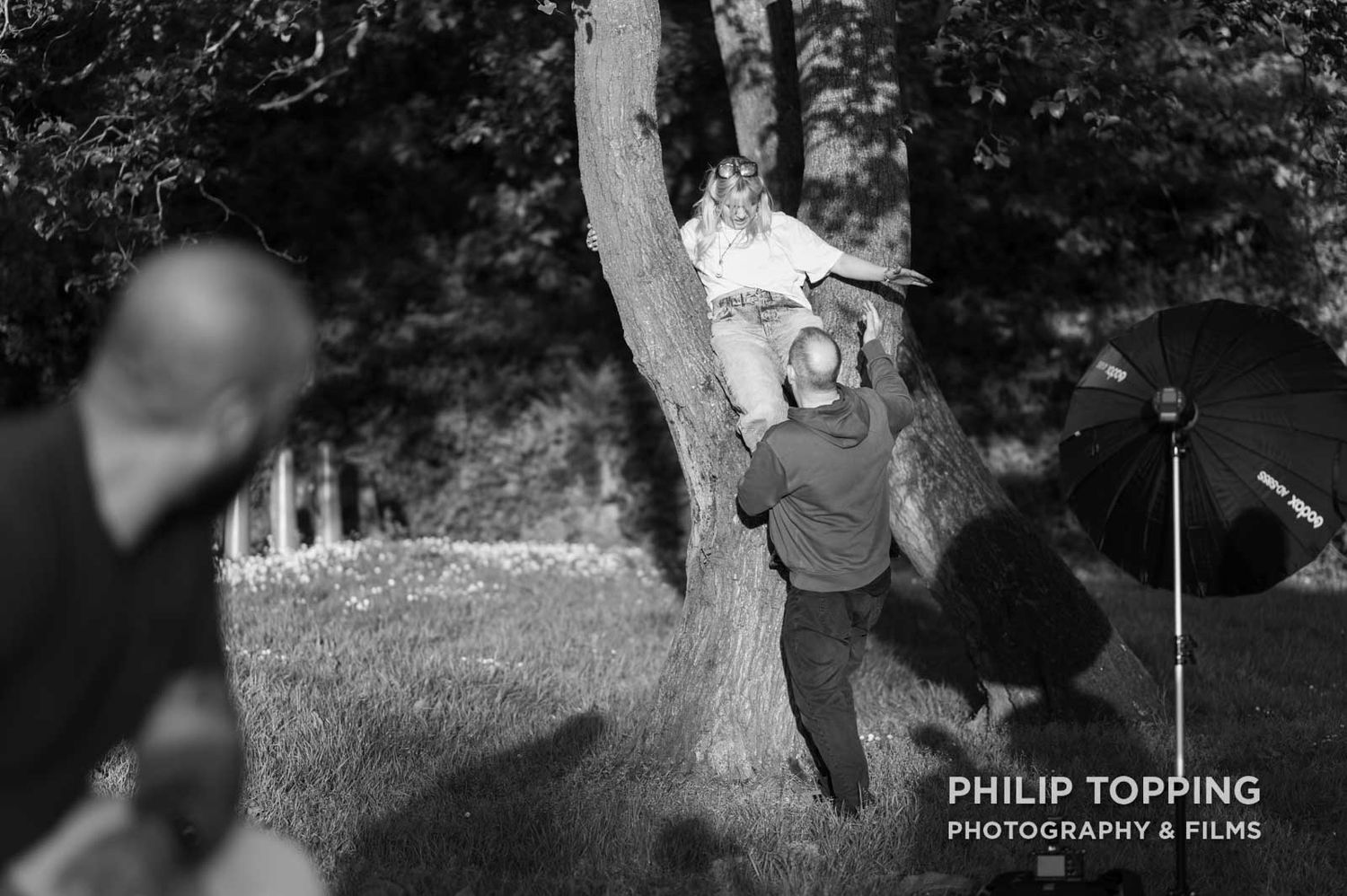 Helping the female model down from a tree.