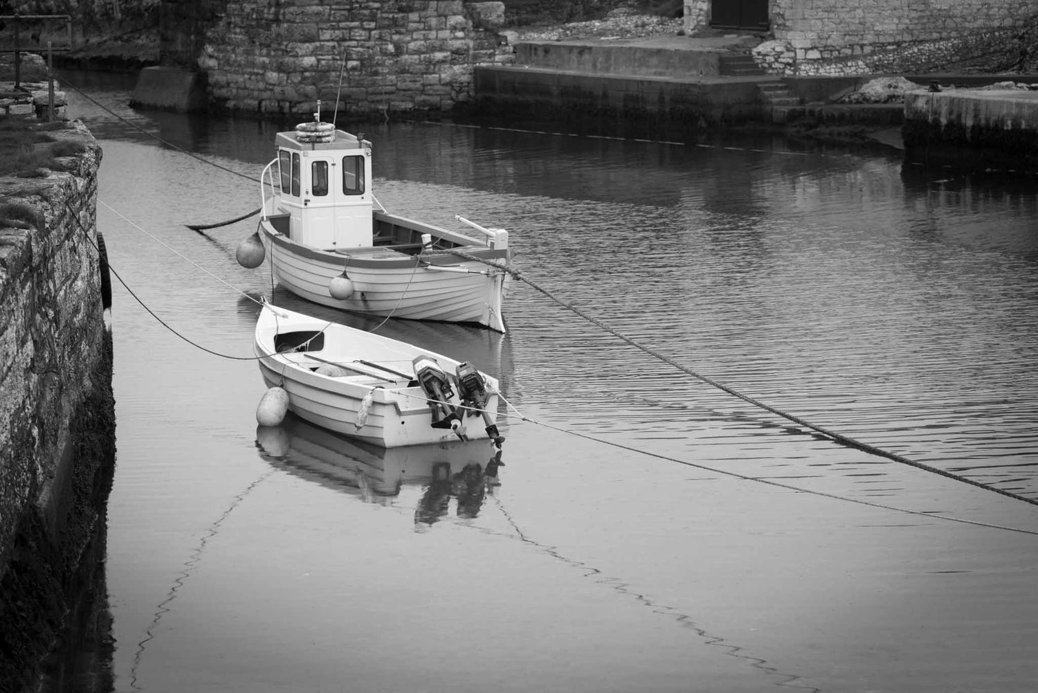 Boats in the harbour are tied up.