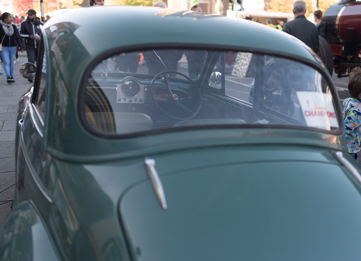 Close-up of the back of an old vintage green car.