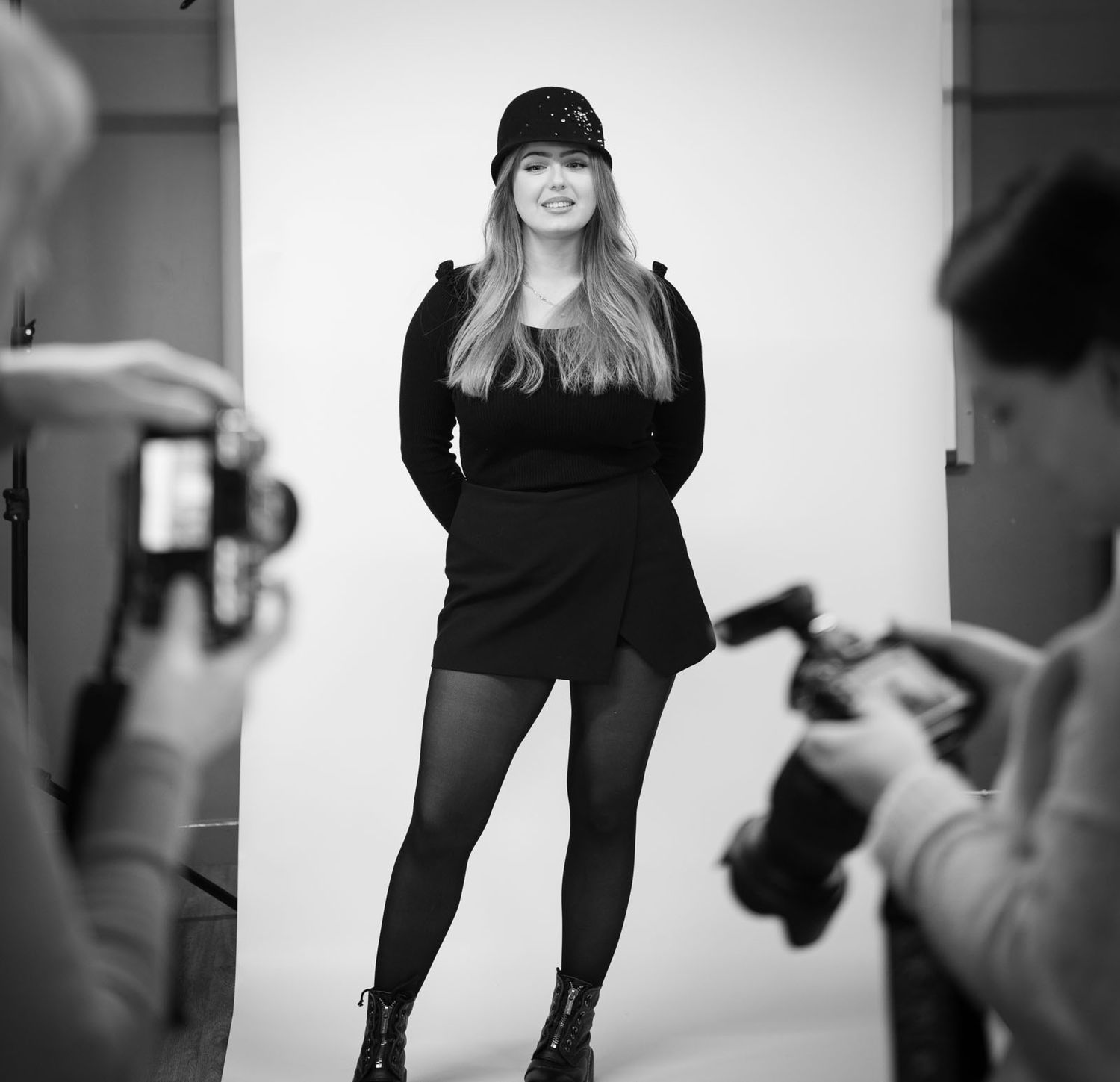 Female portrait behind the scenes with photographers checking images on their cameras in the foreground.