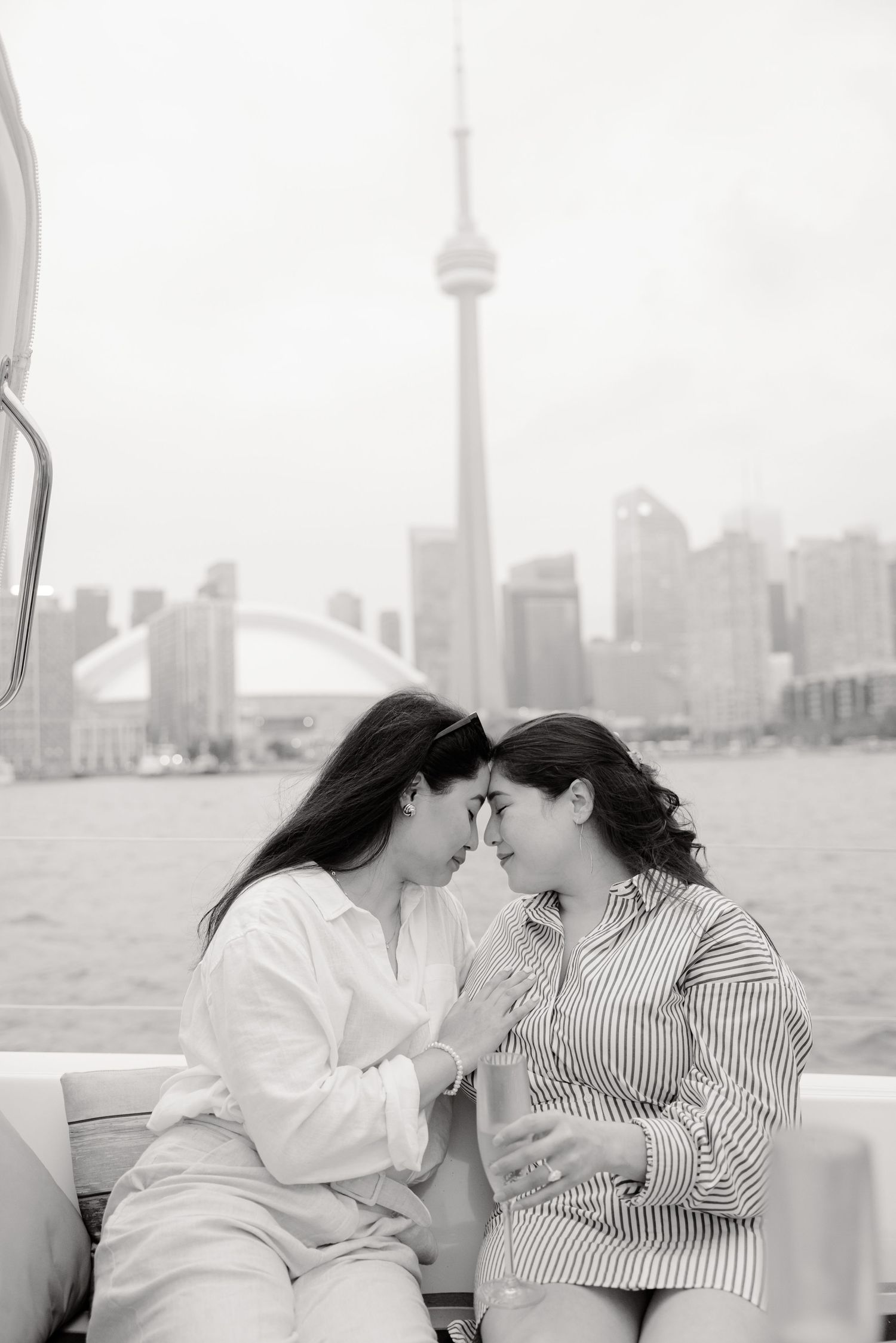 Two people on a boat gazing at each other affectionately with Toronto's skyline in the background.