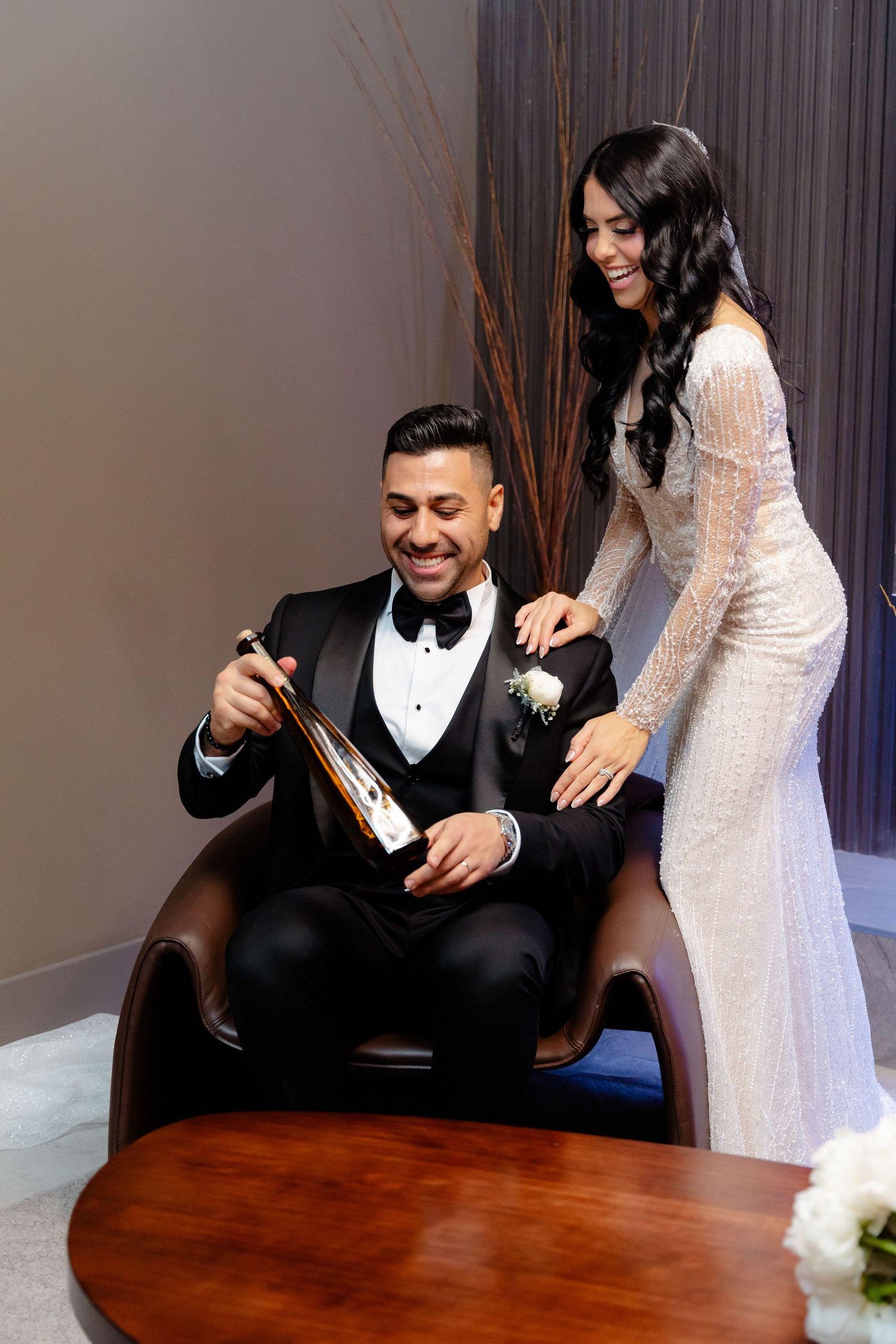 Wedding celebration moment with couple enjoying champagne in stylish lounge setting.